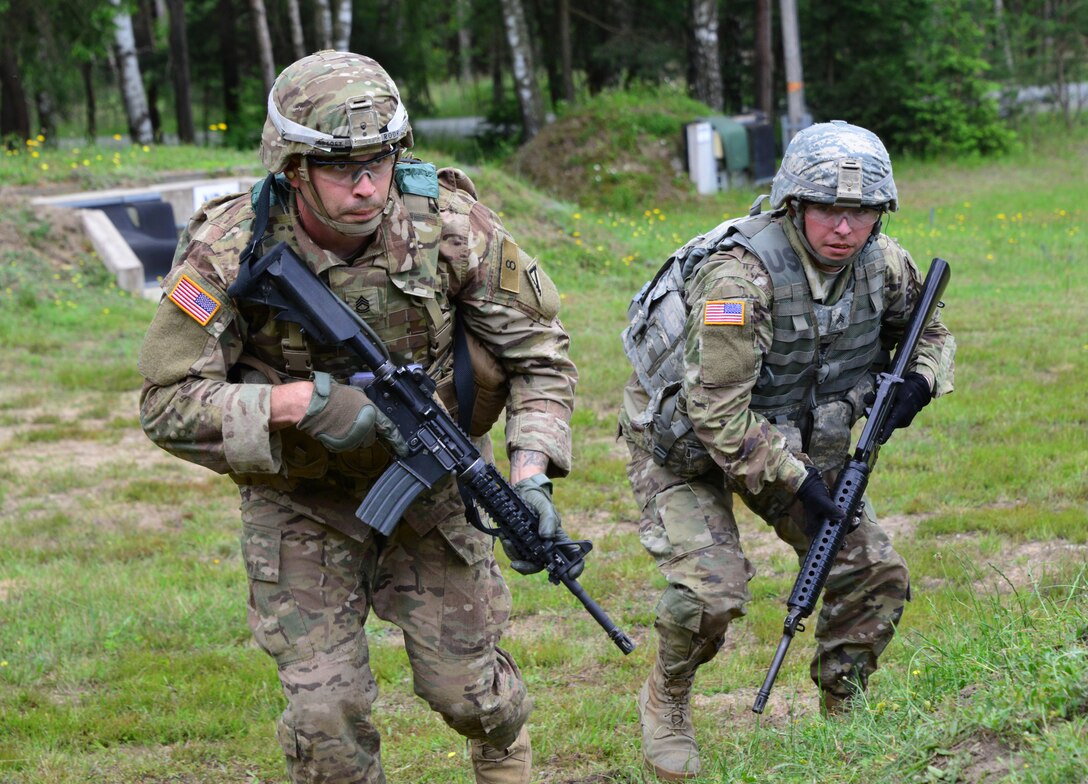 Army Sgt. 1st Class Gabriel Rodriguez, left, engages targets during the Joint Multinational Training Command's Best Warrior competition at Grafenwoehr Training Area, Germany, June 22, 2016. The four-day competition challenges soldiers to prove their skills in military knowledge, leadership and endurance. Rodriguez is assigned to the 7th Army Noncommissioned Officer Academy. U.S. Army photo by Gerhard Seuffert