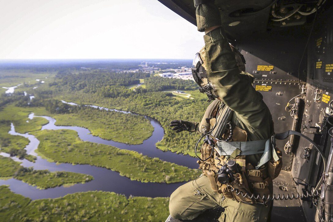 Marine Corps Staff Sgt. Stephen Ferguson rides in the back of a UH-1Y Venom as it approaches a landing zone during a familiarization flight near Camp Lejeune, N.C., June 17, 2016. Such flights give pilots the opportunity to learn different landing zones and flight procedures. Marine Corps photo by Lance Cpl. Aaron K. Fiala