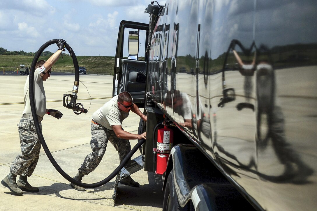 Air Force Staff Sgt. James Fleming and Tech. Sgt. Trampus McDaniel  wind up a fuel hose during Tennessee Maneuvers 2016 at Memphis Air National Guard Base, Tenn., June 21, 2016. Flemming is assigned to the 118th Logistics Readiness Squadron and McDaniel is assigned to the 134th Logistics Readiness Squadron. Both are fuel specialists. Air Force hoto by Staff Sgt. Daniel Gagnon