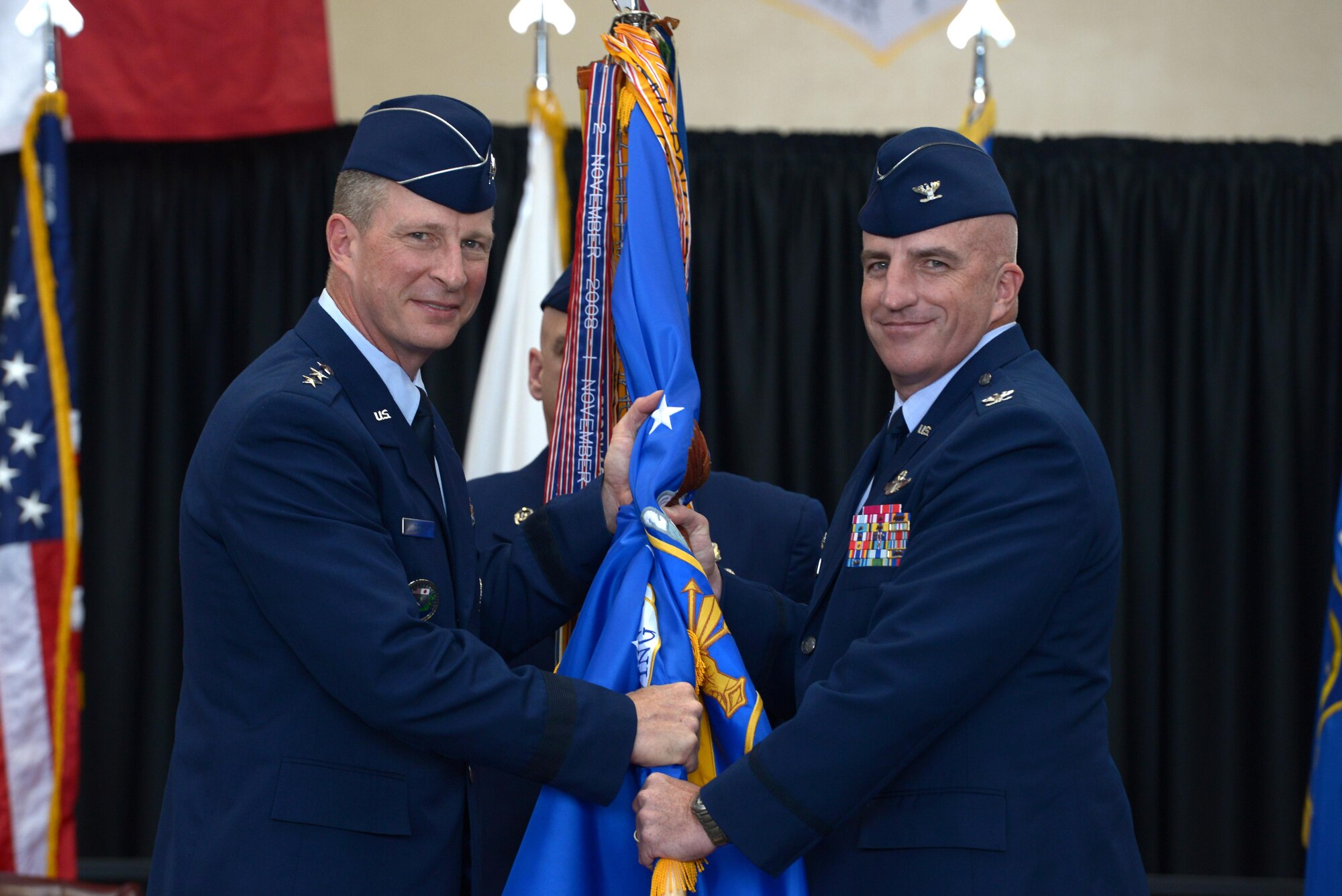 Lt. Gen. John Dolan, U.S. Forces, Japan, and 5th Air Force commander, hands the 374th Airlift Wing guidon to Col. Kenneth Moss, 374 AW incoming commander, during the official wing change of command at Yokota Air Base, Japan, June 24, 2016. Moss praised the 374 AW for their accolades and mentioned his excitement to continue to build on their excellent reputation and the strong U.S.-Japan partnership. (U.S. Air Force photo by Staff Sgt. Cody H. Ramirez/Released)