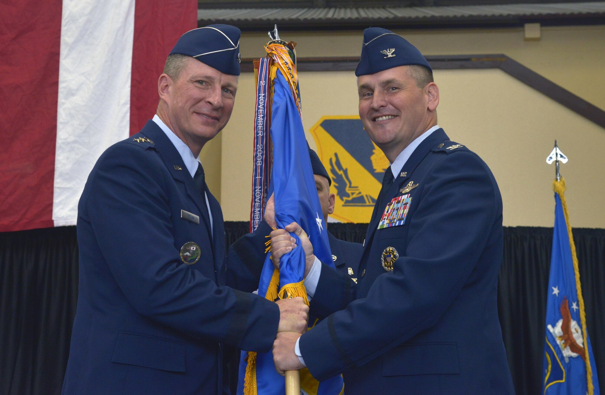 Lt. Gen. John Dolan, U.S. Forces, Japan, and 5th Air Force commander, receives the 374th Airlift Wing guidon from Col. Douglas DeLaMater, 374 AW outgoing commander, during the change of command ceremony at Yokota Air Base, Japan, June 24, 2016. A change of command is a military tradition that represents a formal transfer of authority and responsibility for a unit from one commanding or flag officer to another. (U.S. Air Force photo by Senior Airman David Owsianka/Released)