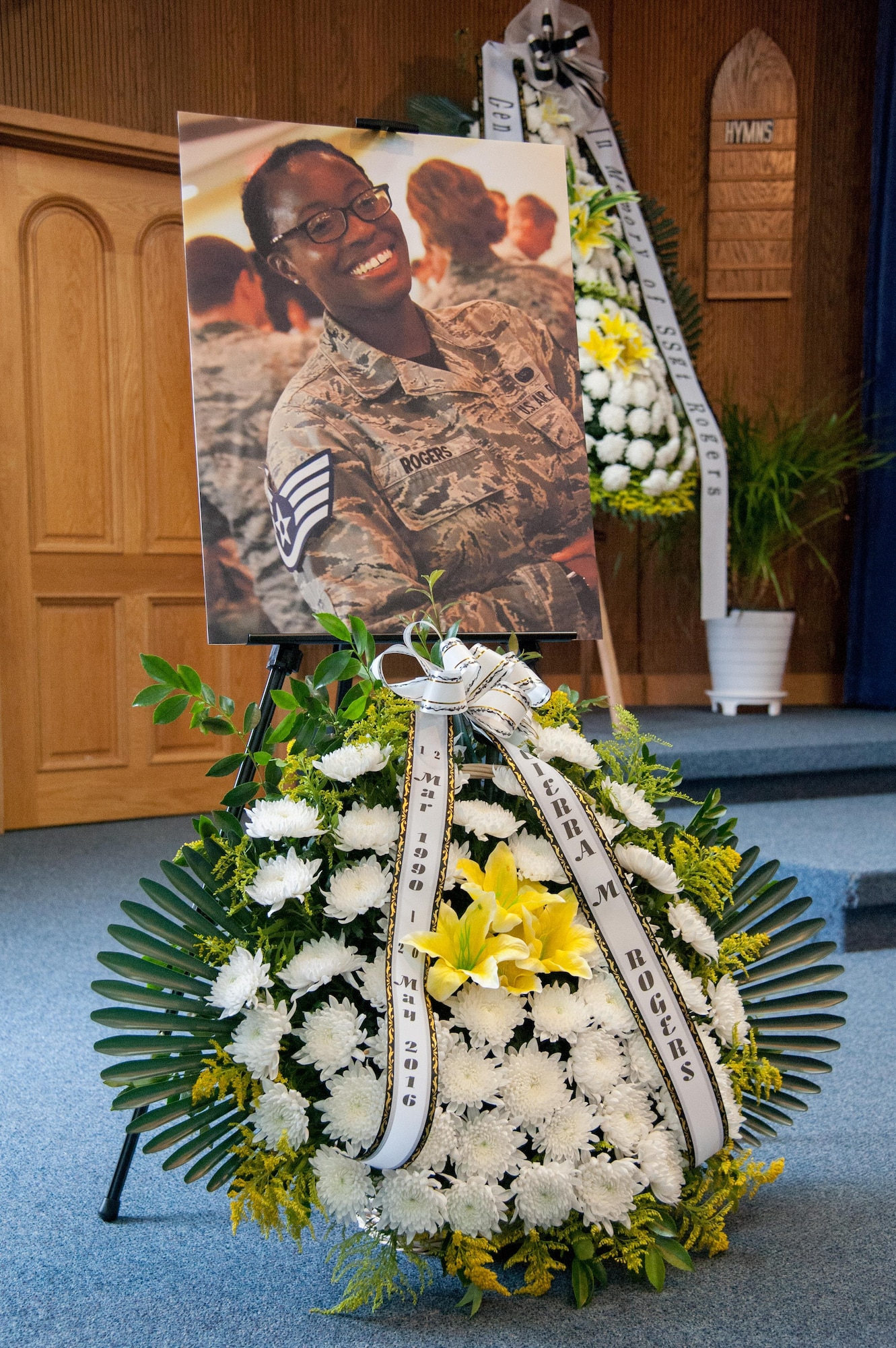 A photo of Staff Sgt. Cierra Rogers and wreath sit at the front of the base chapel during her memorial service at Osan Air Base, Republic of Korea, June 24, 2016.  Military and civilian members of the Osan and Pyeongtaek community gathered alongside the Rogers family to honor Sergeant Rogers, a 731st Air Mobility Squadron Airman, who died May 20. (U.S. Air Force photo by Staff Sgt. Jonathan Steffen)