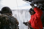 Alaska Air Guardsman Capt. Johh Romspert, a 212th Rescue Squadron combat rescue officer, prepares to be lowered via hoist out of an HH-60 Pave Hawk Helicopter during a training mission held near Mount Susitna Dec. 16.