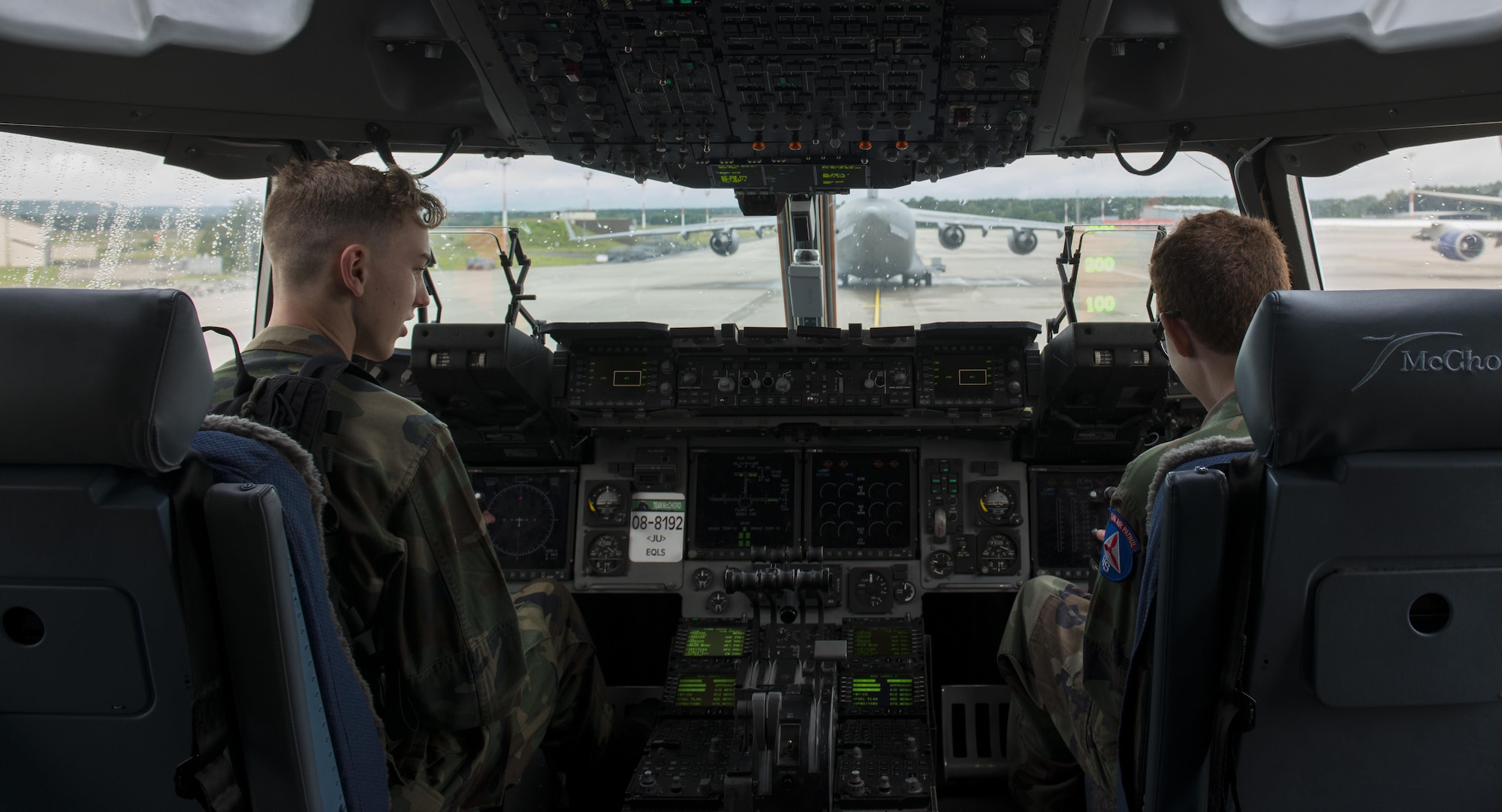 Two Civil Air Patrol cadets sit in the flight deck of a C-17A Globemaster III aircraft during a tour June 21, 2016, at Ramstein Air Base, Germany. The 721st Aircraft Maintenance Squadron hosted this portion of the tour, allowing the cadets to see inside the plane. CAP toured Ramstein from June 18 to 24, and visited squadrons associated with all three wings on base to get a glimpse of what life is like as an Airman. (U.S. Air Force photo/Airman 1st Class Tryphena Mayhugh)