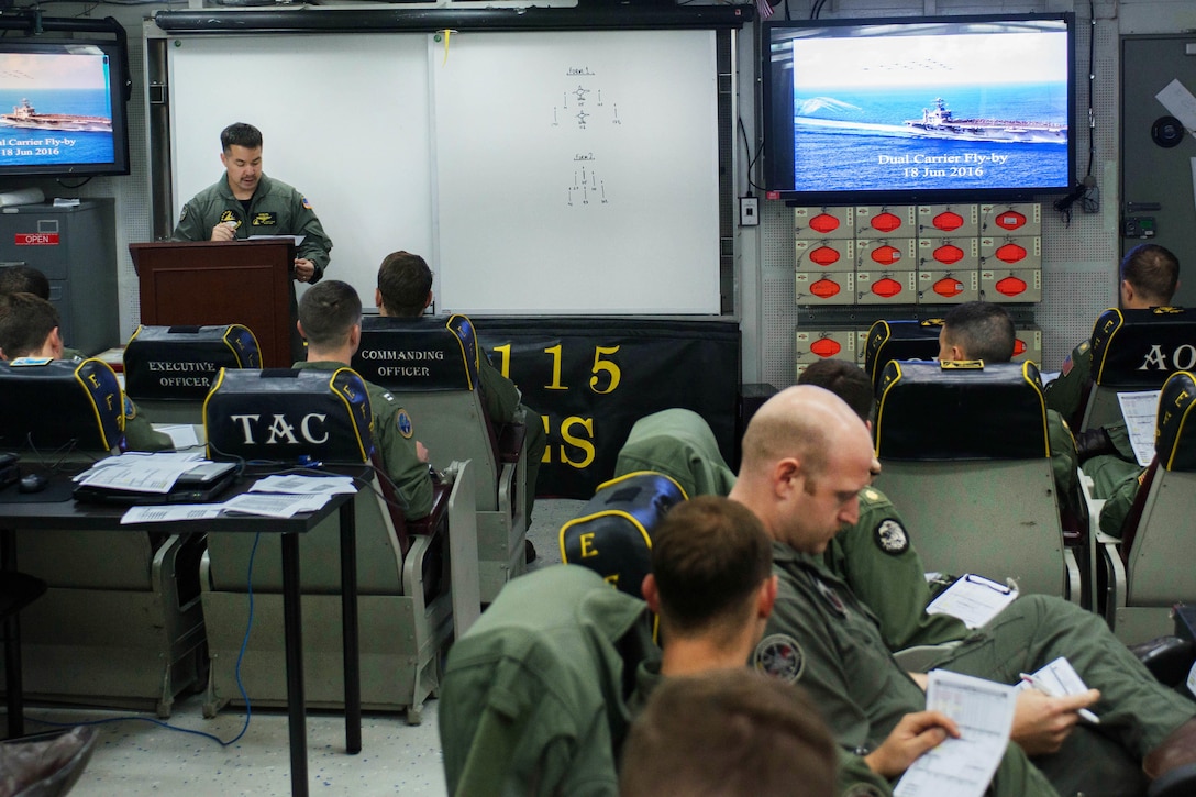 Navy Cmdr. Doug Gray, standing, commander of Strike Fighter Squadron 115, briefs pilots before a formation flight above the Nimitz-class aircraft carriers USS John C. Stennis and USS Ronald Reagan in the Philippine Sea, June 18, 2016. The squadrons are supporting security and stability in the Indo-Asia-Pacific region. Navy photo by Petty Officer 3rd Class Sara B. Sexton 