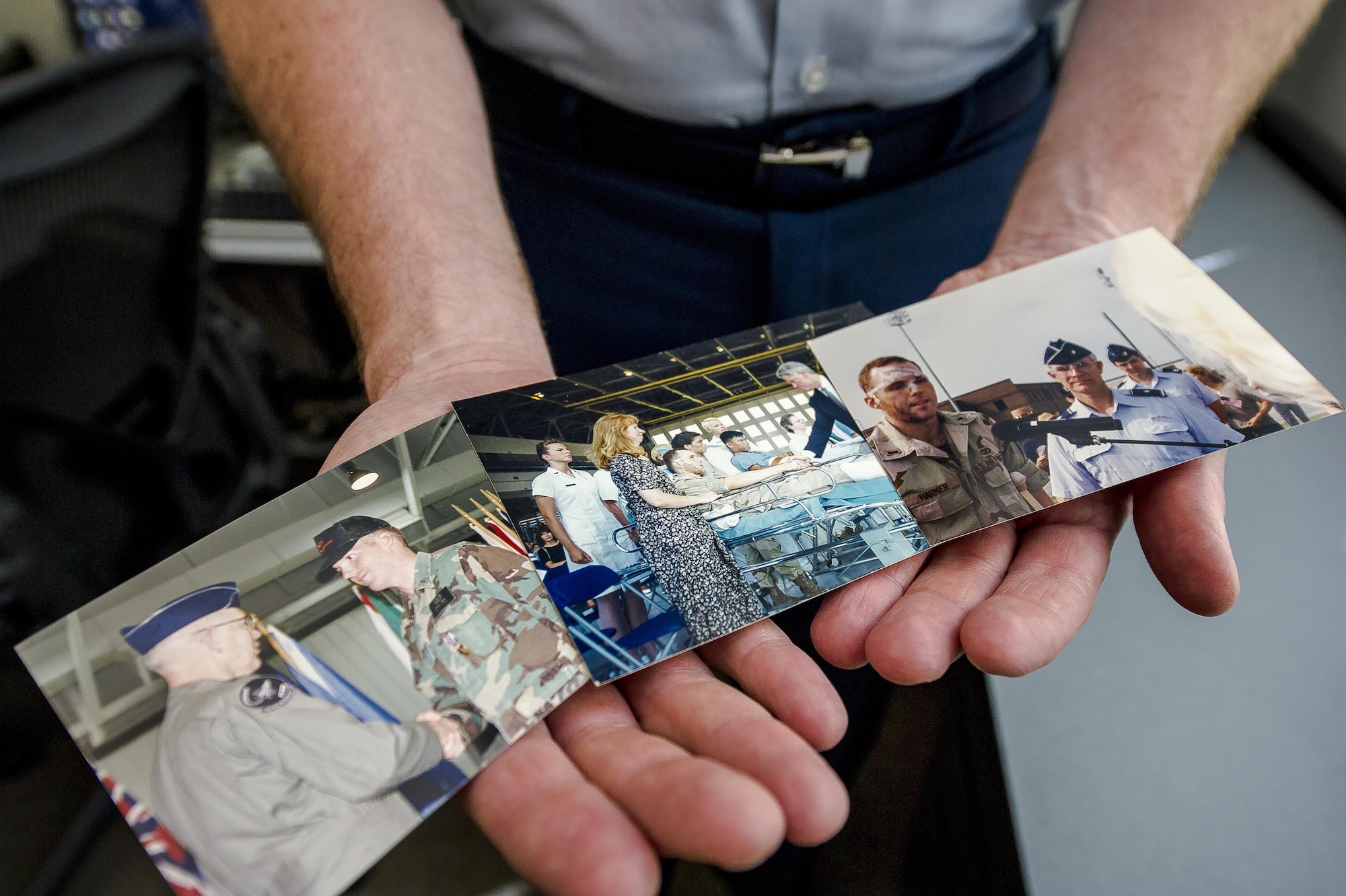 Col. Michael Harner, the associate director of civil engineers at the Pentagon in Washington, D.C., shows photos of himself June 9, 2016, following the terrorist attack on the Khobar Towers complex in Dharan, Saudi Arabia, on June 25, 1996. The photos included him receiving his Purple Heart and meeting former President Bill Clinton just days after the attack at Eglin Air Force Base, Fla. The attack killed 19 Airmen and injured more than 350 people. (U.S. Air Force photo/Staff Sgt. Christopher Gross)