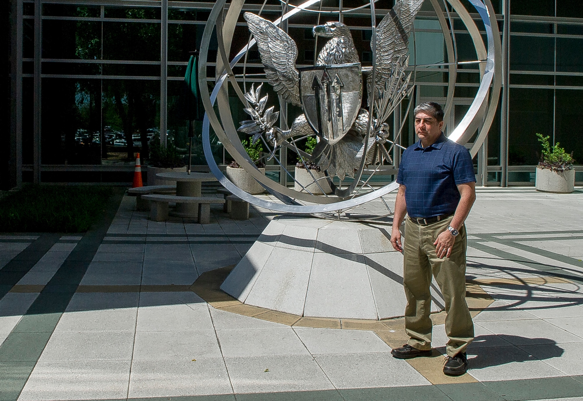 Alfredo Guerrero sits in front of the Defense Threat Reduction Agency building at Fort Belvoir, Va., on June 10, 2016, where he works as the anti-terrorism program manager. Guerrero was on top of Bldg. 131 of the Khobar Towers complex in Dharan, Saudi Arabia, on June 25, 1996, when he spotted a suspicious large gas truck drive toward the building. When the truck parked and two men jumped out and got into a car that had been following them, Guerrero and two other Airmen immediately began evacuating the building. A short time later the truck exploded, killing 19 Airmen and injuring more than 350 people. (U.S. Air Force photo/Staff Sgt. Christopher Gross)