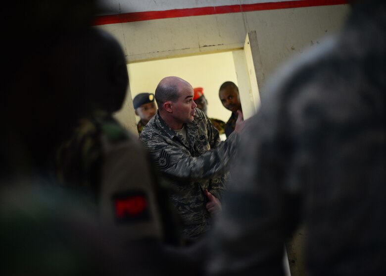 U.S. Air Force Tech. Sgt. Andrew Acosta, 818th Mobility Support Advisory Squadron security forces advisor, helps Kenyan Defense Forces prepare for close quarter combat training during African Partnership Flight Kenya at Laikipia Air Base, Kenya, June 23, 2016. More than 50 U.S. Air Force Airmen participated in the first APF in Kenya. The APF is designed for U.S. and African partner nations to work together in a learning environment to help build expertise and professional knowledge and skills. (U.S. Air Force photo by Tech. Sgt. Evelyn Chavez/Released)