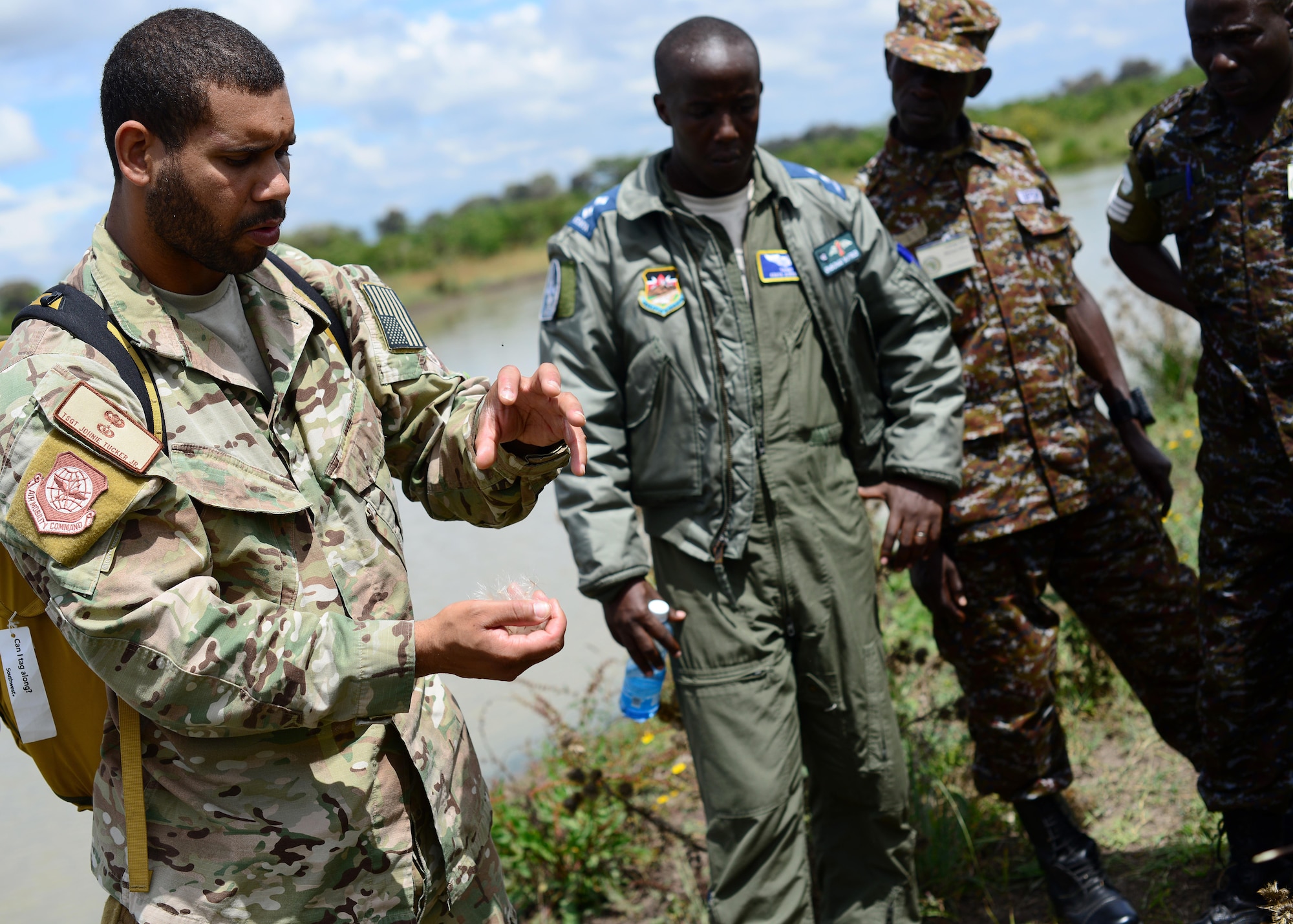 U.S. Air Force Tech. Sgt. Johnie Tucker, 818th Mobility Support Advisory Squadron survival evasion resistance and escape specialist air advisor, discusses survival techniques with Kenyan Defense Force members at Laikipia Air Base, Kenya, June 23, 2016. More than 50 U.S. Air Force Airmen participated in the first African Partnership Flight in Kenya. The APF is designed for U.S. and African partner nations to work together in a learning environment to help build expertise and professional knowledge and skills in key areas such as personnel recovery command and control, survival and evasion principles and tactical combat casualty care. (U.S. Air Force photo by Tech. Sgt. Evelyn Chavez/Released)