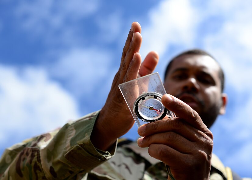 U.S. Air Force Tech. Sgt. Johnie Tucker, 818th Mobility Support Advisory Squadron survival evasion resistance and escape specialist air advisor, demonstrates navigation skills for Kenyan Defense Force members at Laikipia Air Base, Kenya, June 23, 2016. More than 50 U.S. Air Force Airmen participated in the first African Partnership Flight in Kenya. The APF is designed for U.S. and African partner nations to work together in a learning environment to help build expertise and professional knowledge and skills in key areas such as personnel recovery command and control, survival and evasion principles and tactical combat casualty care. (U.S. Air Force photo by Tech. Sgt. Evelyn Chavez/Released)