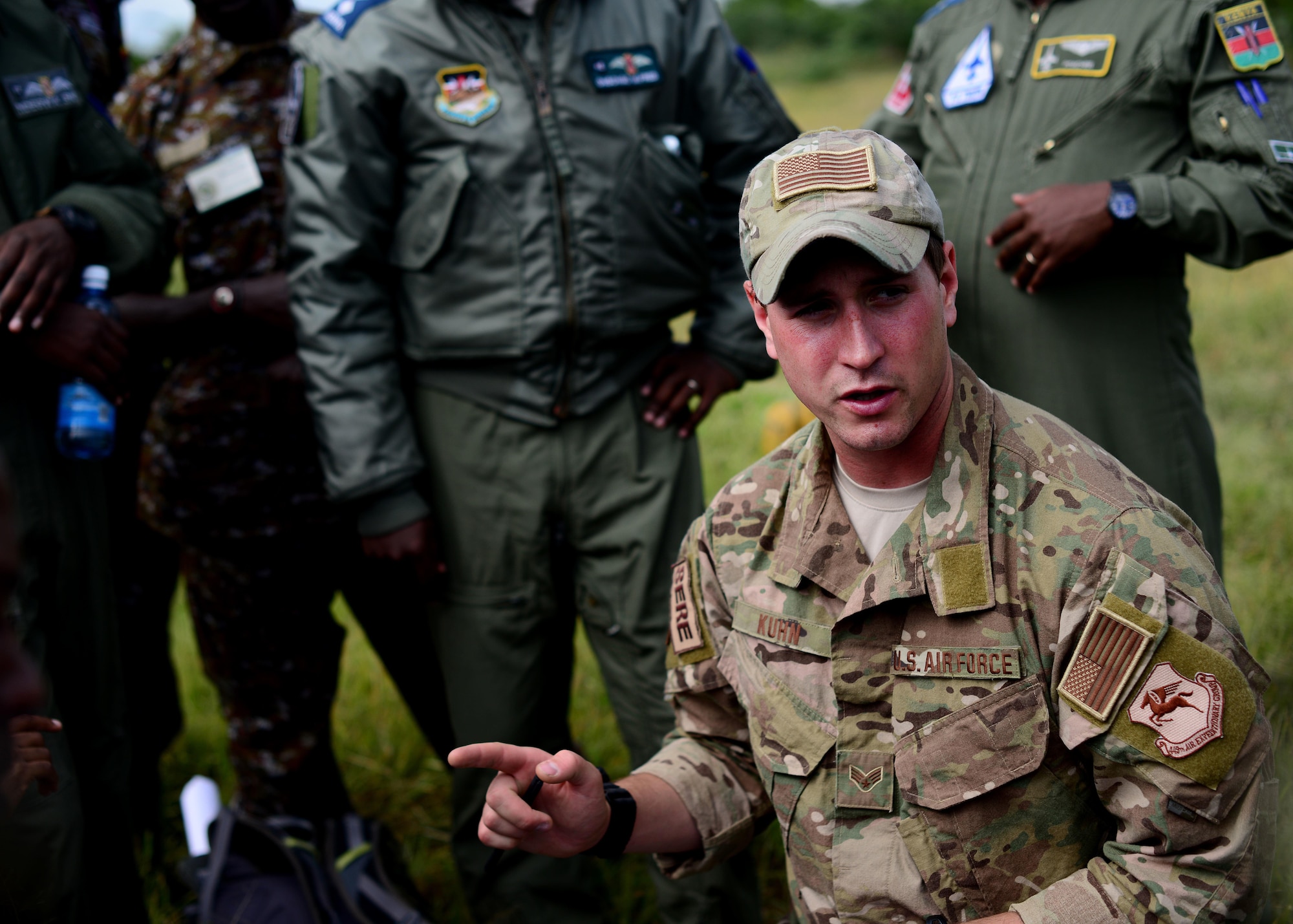 U.S. Air Force Senior Airman Ian Khun, 82nd Expeditionary Rescue Squadron, survival evasion resistance and escape specialist, discusses land navigation instruction with Kenyan Defense Force members at Laikipia Air Base, Kenya, June 23, 2016. More than 50 U.S. Air Force Airmen participated in the first African Partnership Flight in Kenya. The APF is designed for U.S. and African partner nations to work together in a learning environment to help build expertise and professional knowledge and skills in key areas such as personnel recovery command and control, survival and evasion principles and tactical combat casualty care.  (U.S. Air Force photo by Tech. Sgt. Evelyn Chavez/Released)