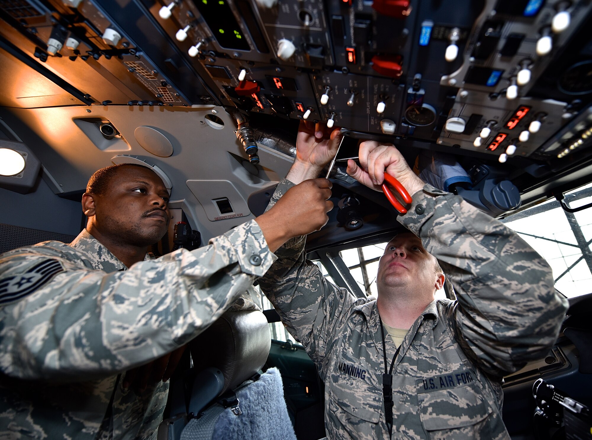 Tech. Sgt. Aaron Flanigan, left, an avionics tech with the 932nd Aircraft Maintenance Squadron assists Tech. Sgt. Billy Manning, sheets metal worker with the 932nd Maintenance Squadron to repair an overheated heads up display and replace a nut plate, May 2, 2016, Scott Air Force Base, Illinois.  (U.S. Air Force photo by Christopher Parr)
