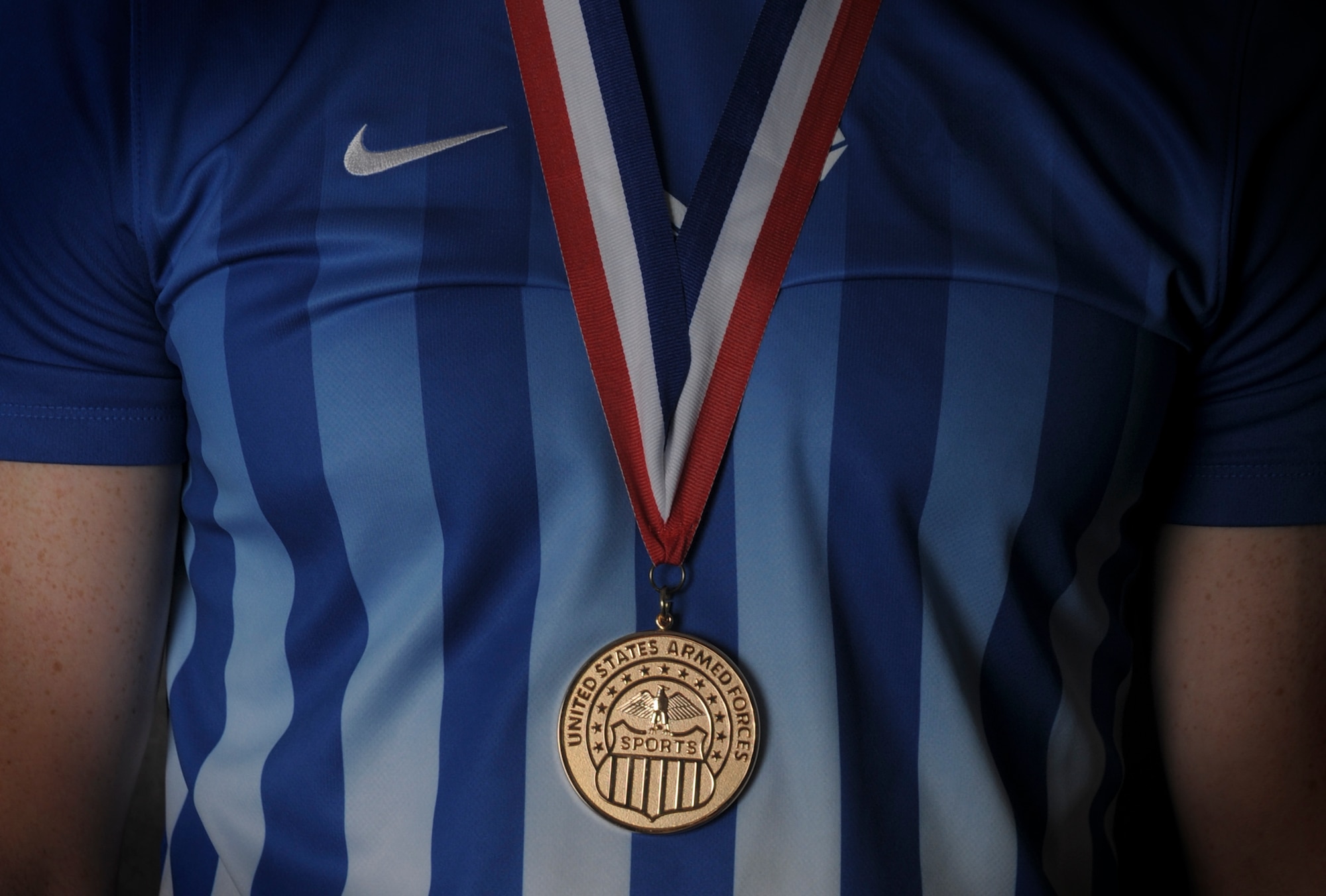 Airman 1st Class Timothy Bettes, 48th Force Support Squadron career development technician wears the Armed Forces Men’s soccer championship medal, June 23, 2016 at Royal Air Force Lakenheath, England. The Air Force men’s soccer team played the U.S. Navy for the championship, May 19, 2016 at Fort Benning, Georgia, winning 3-2. (U.S. Air Force photo/Senior Airman Dawn M. Weber)