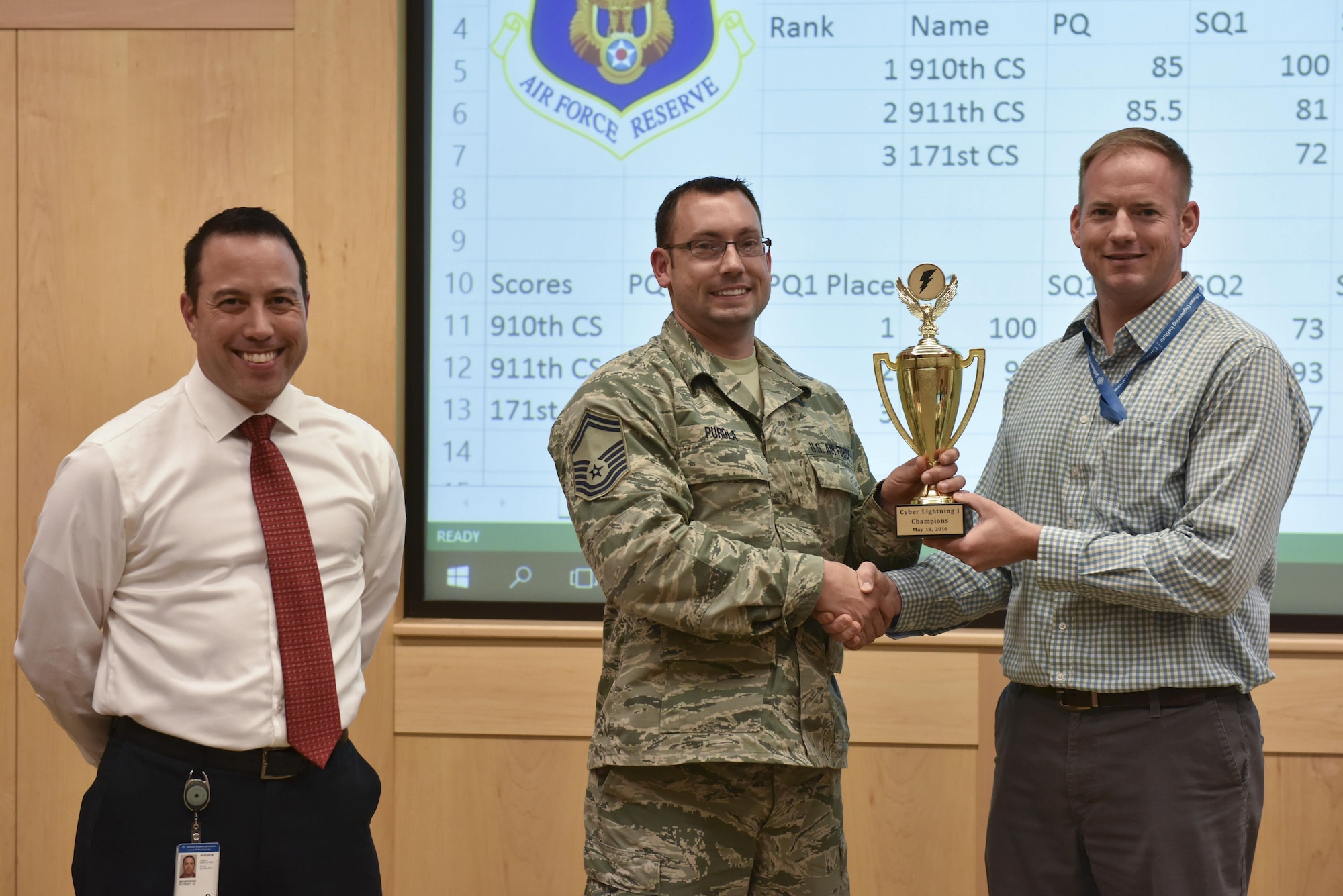 Captain Geoffrey Dobson, cyber war gaming program manager at Carnegie Melon University and officer in charge of cyber assurance with the 911th Airlift Wing, and Master Sgt. Robert Beveridge, and software engineer at CMU and computer systems operator with the 910th Airlift Wing, present a trophy to Senior Master Sgt. Jamie Purola, cyber operations flight chief with the 910th Airlift Wing, at Carnegie Melon University, Pennsylvania, May 18, 2016. The 910th was the winner of the Cyber Lightning exercise held at CMU, where teams from the 911th AW, the 910th AW and the 171st Air Refueling Squadron competed to eliminate cyber threats in a training cyber environment. (U.S. Air Force photo by Airman Beth Kobily)