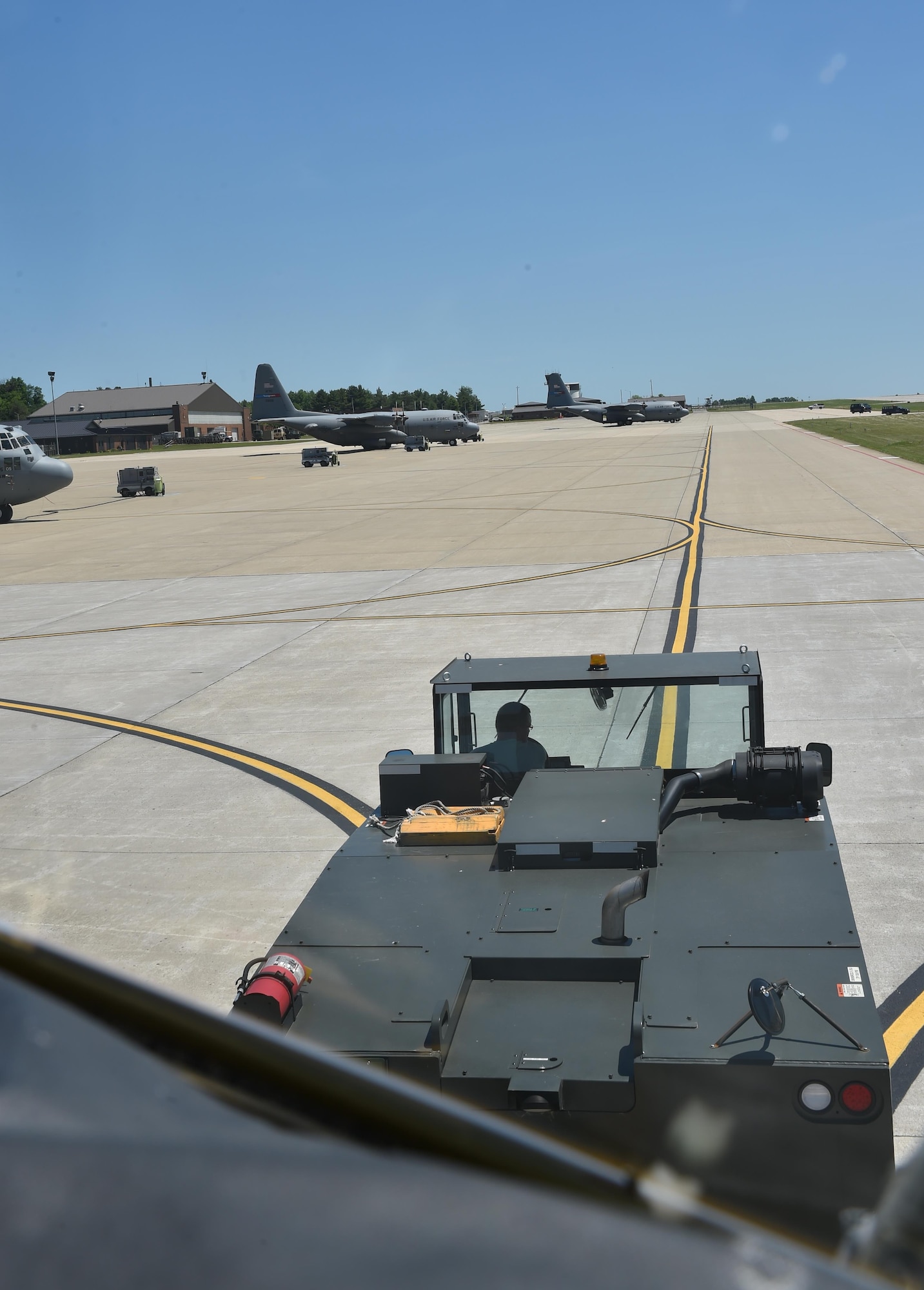 Staff Sgt. Gene Tucholski a C-130 crew chief with the 910th Aircraft Maintenance Squadron, operates the braking system of a C-130 Hercules aircraft during towing operations here, June 14, 2016. Maintenance uses teams of spotters and operators to safely move aircraft between hangars and parking spots. (U.S. Air Force photo/Staff Sgt. Rachel Kocin)