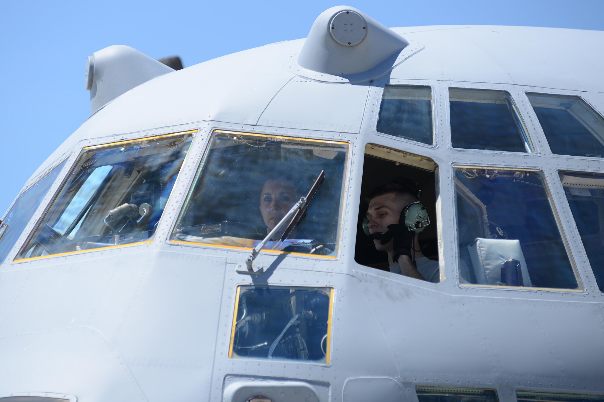 Staff Sgt. Gene Tucholski, a C-130 crew chief with the 910th Aircraft Maintenance Squadron (wearing headset), operates the braking system of a C-130 Hercules aircraft during towing operations while Staff Sgt. Rachel Kocin, a Photojournalist for the 910th Public Affairs Office, observes here June 14, 2016. Maintenance uses several Airmen as operators and spotters to move aircraft between hangars and parking spots. (U.S. Air Force photo/Tech. Sgt. James Brock)
