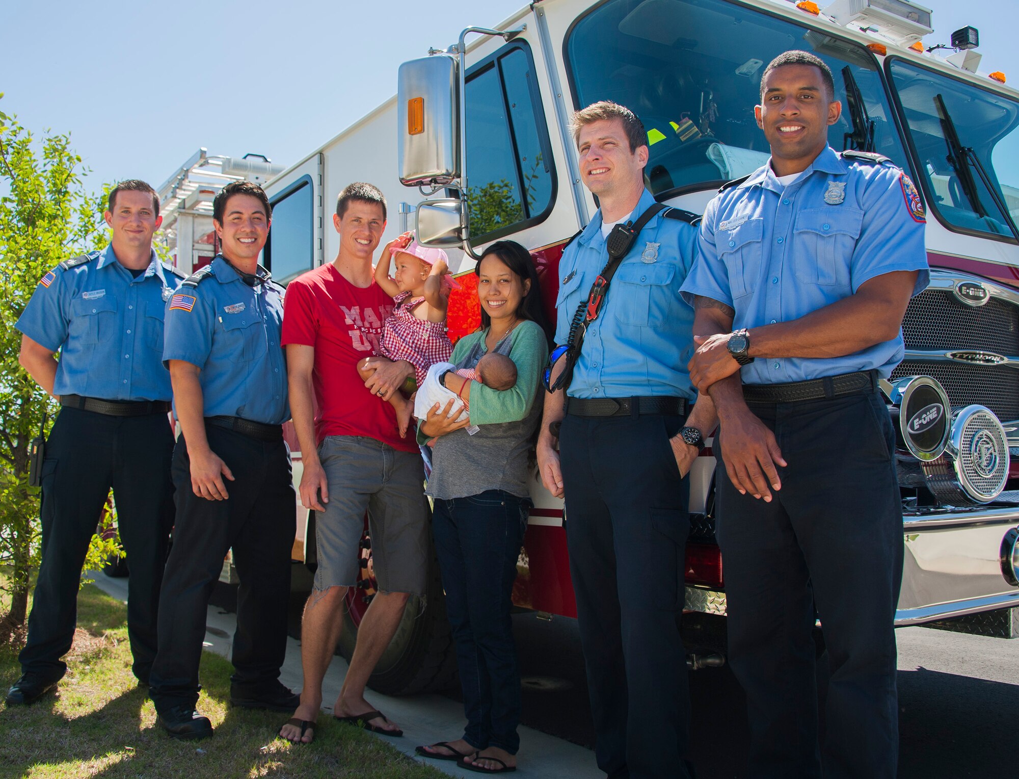 Kyle Vaughn, Timothy Panzer, Mark Merrill and Walter Carney, all 96th Civil Engineer Group firefighters, stand with Airman 1st Class Josiah Zimmerman, his wife, Leana, and their children during a visit June 20, 2016, at Eglin Air Force Base, Fla. The firefighters helped the Zimmermans deliver their baby boy, Luca, at their home on base after responding to a 911 call. (U.S. Air Force photo/Ilka Cole)