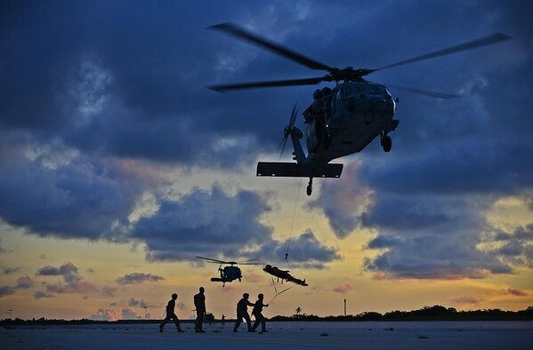 Airmen, Sailors and Soldiers perform an emergency evacuation hoist during a jungle training course June 15, 2016, at Andersen Air Force Base, Guam. Conducted by the Army’s 25th Infantry Division's Lightning Academy Jungle Operations Training Center from Oahu, Hawaii, and supported by 736th Security Forces Squadron Commando Warrior cadre, students prepared a simulated patient for medical evacuation. During the course, service members also learned survival skills, including land navigation and evasion techniques. (U.S. Air Force photo/Senior Airman Joshua Smoot)