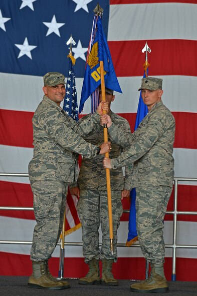 U.S. Air Force Col. Douglas Thies, 20th Operations Group commander, hands the 20th Operations Support Squadron guidon to Lt. Col. Jay Thomas, 20th OSS incoming commander, during a change of command ceremony at Shaw Air Force Base, S.C., June 24, 2016. The ceremony formally recognized Thomas’ assumption of command from the squadron’s previous commander, Lt. Col. Jared Johnson. (U.S. Air Force photo by Airman 1st Class Christopher Maldonado)