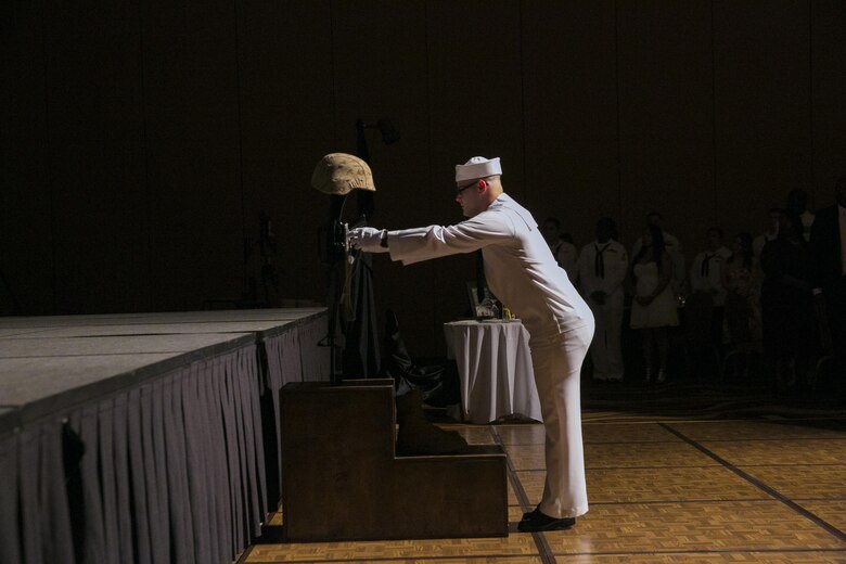 A sailor hangs the dog tag of a fallen corpsman on a battlefield cross to honor the ultimate sacrifice the corpsman made as part of the 118th Hospital Corpsman Ball at Pechanga Resort and Casino in Temecula Calif., June 17, 2016. (Official Marine Corps photo by Lance Cpl. Dave Flores/Released)