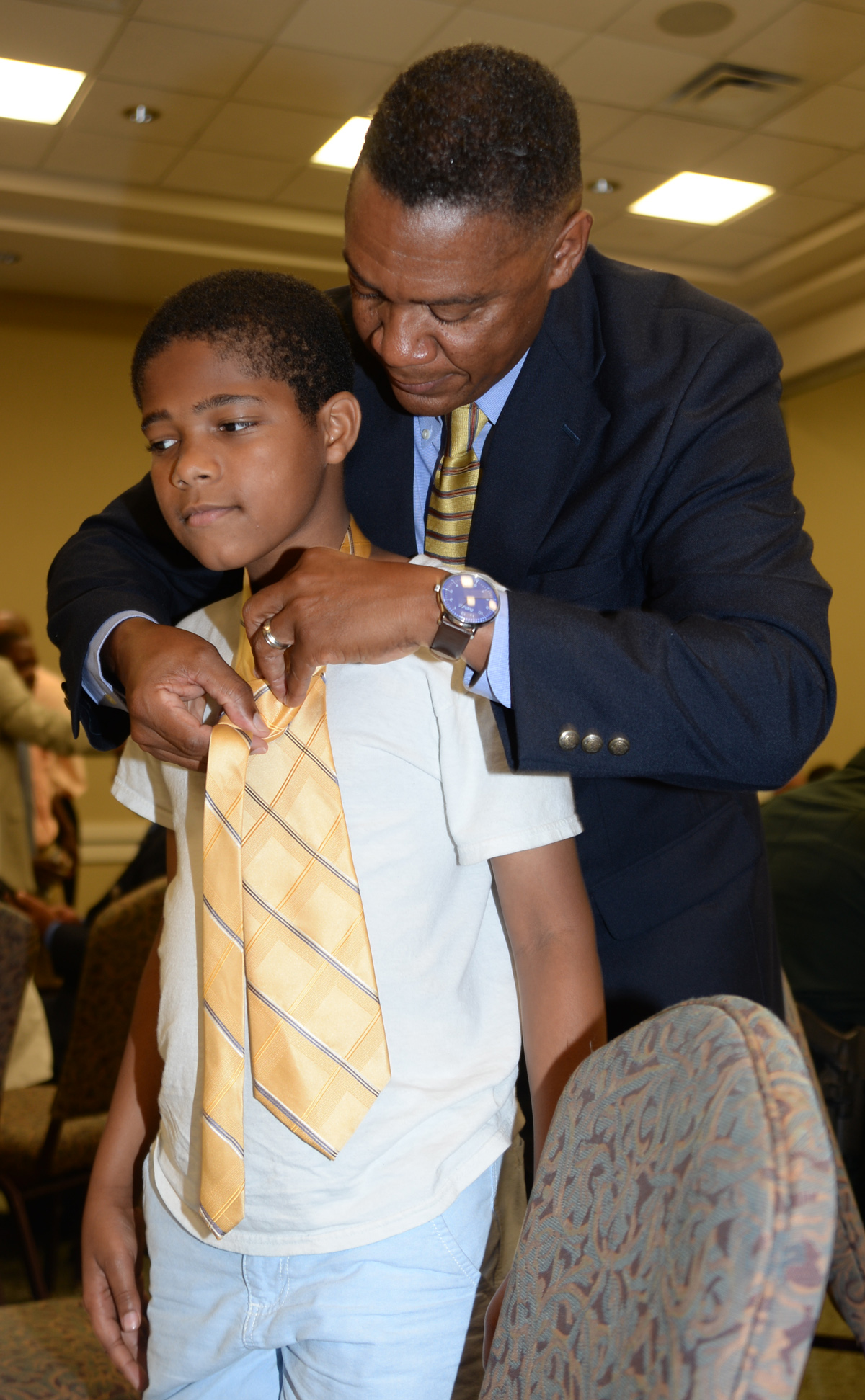 Maj. Gen. Craig Crenshaw, commanding general, Marine Corps Logistics Command, teaches a young boy how to properly tie a neck during the 2nd annual Ties that Bind event, June 16.  This event, sponsored by Phoebe Putney Memorial Hospital’s Network of Trust bonded 50 local men with 50 boys throughout the community using neck ties and sharing life lessons.