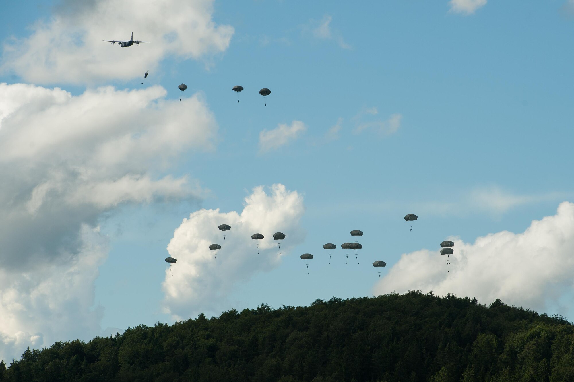 Multinational paratroopers jump out of a U.S. Air Force C-130J Super Hercules onto the drop zone at Hohenfels Training Area, Germany during Exercise Swift Response 16, June 15, 2016. Exercise SR16 is one of the premier military crisis response training events for multinational airborne forces in the world, the exercise has more than 5,000 participants from 10 NATO nations. (U.S. Air Force photo by Master Sgt. Joseph Swafford/Released) 
