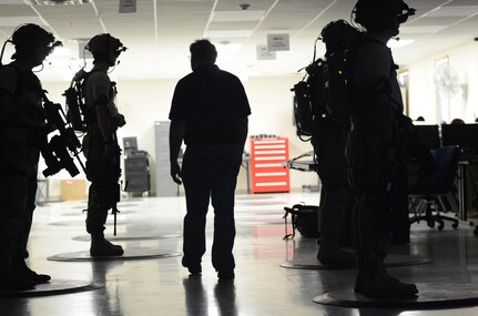 Rance Clark, the primary technician for Fort McCoy's Dismounted Soldier Training System (DSTS) inspects the equipment worn by military police Soldiers training with a virtual reality simulator during exercise Guardian Justice at Fort McCoy, Wisc., June 21, 2016. The DSTS prepares soldiers for real world challenges through practice in a virtual environment. (U.S. Army photo by Spc. Adam Parent)