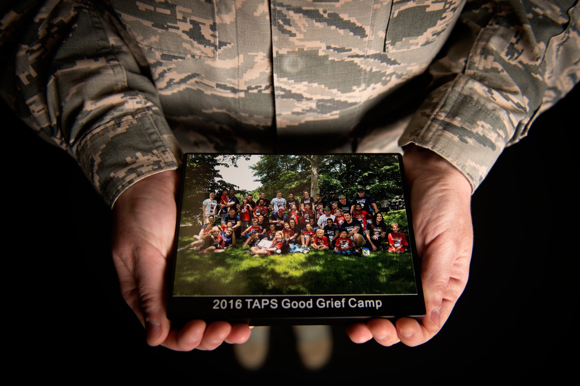 Staff Sgt. Destini Yaden, a mental health specialist assigned to the 27th Special Operations Medical Operations Squadron, shows a photo of significance to her June 15, 2016, at Cannon Air Force Base, N.M. “The significance of the photo is because the girl I mentored for nine years, was mentoring for her first time,” said Yaden. “Also I was able to be mentor to the son of one of my fallen friends.”(U.S. Air Force photo/Tech. Sgt. Manuel Martinez) 