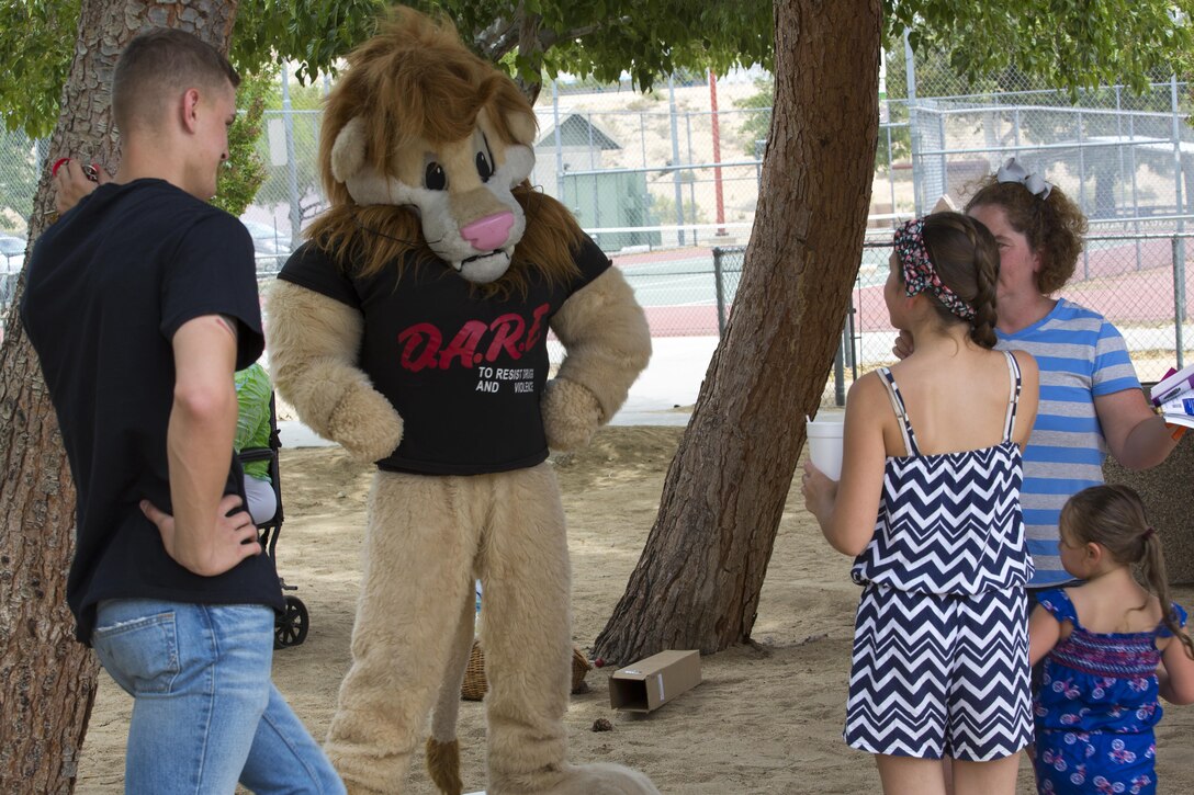 The Provost Marshal Office’s Drug Abuse Resistance Education Lion, Daren, interacts with community members during the Joshua Tree Community Days Summer Splash at the Joshua Tree Community Center in Joshua Tree, Calif., June 18, 2016. (Official Marine Corps photo by Lance Cpl. Levi Schultz/Released)