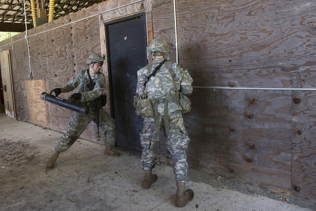 Army Spcs. John Nicastro, left, and Forrest Watkins prepare to breach a door during annual training at Camp Ethan Allen Training Site, Jericho, Vt., June 15, 2016. Nicastro and Watkins are assigned to the Vermont National Guard’s Company A, 3rd Battalion, 172nd Infantry Regiment, 86th Infantry Brigade Combat Team. Air National Guard photo by Tech. Sgt. Sarah Mattison