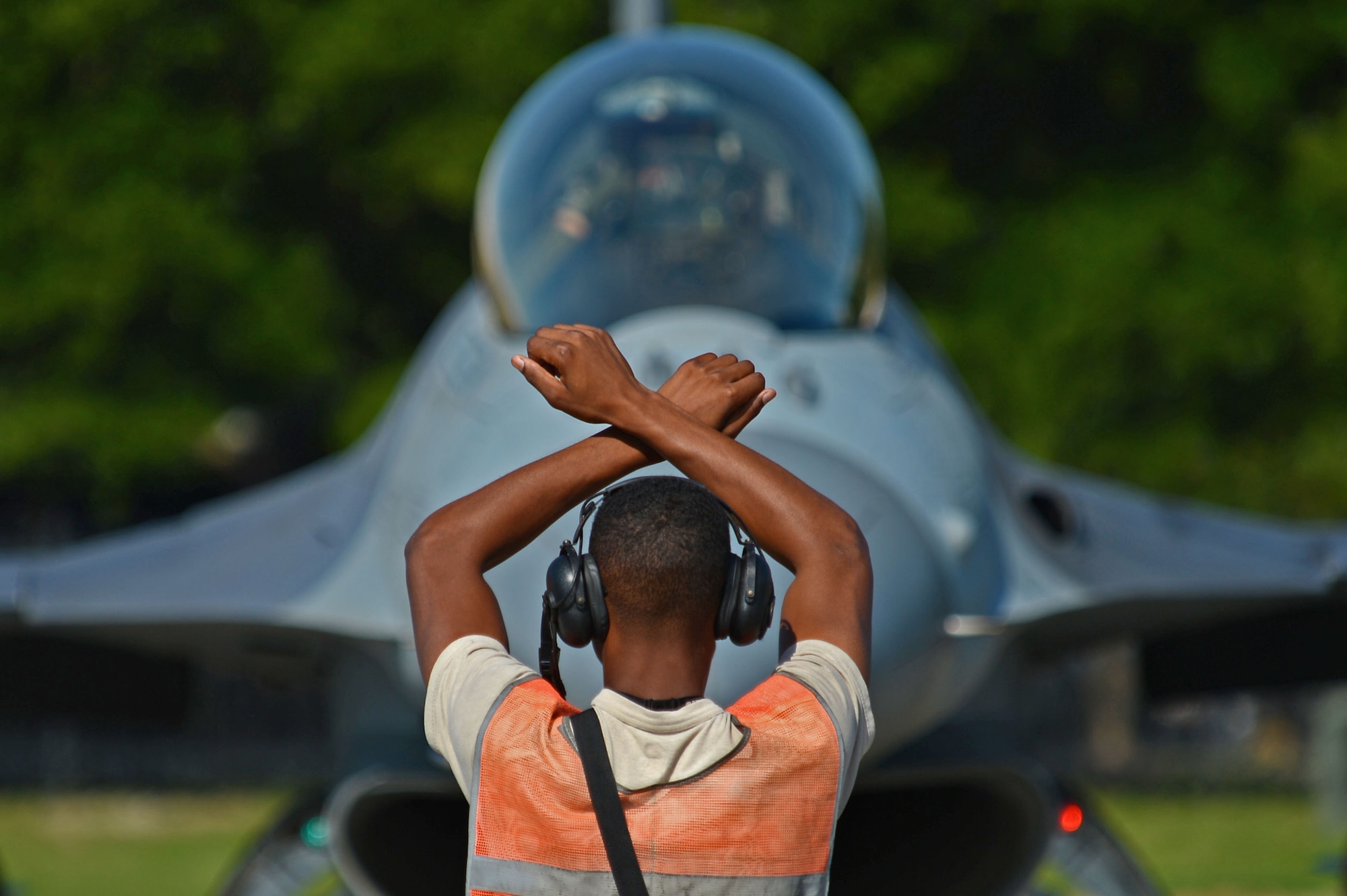 U.S. Air Force Airman 1st Class Cameron Crawford, 20th Aircraft Maintenance Squadron tactical aircraft maintainer, marshals an F-16CM Fighting Falcon for hot-pit refueling during a surge at Shaw Air Force Base, S.C., June 21, 2016. Throughout the surge, tactical aircraft maintainers marshalled over 30 aircraft a day. (U.S. Air Force photo by Airman 1st Class Christopher Maldonado)