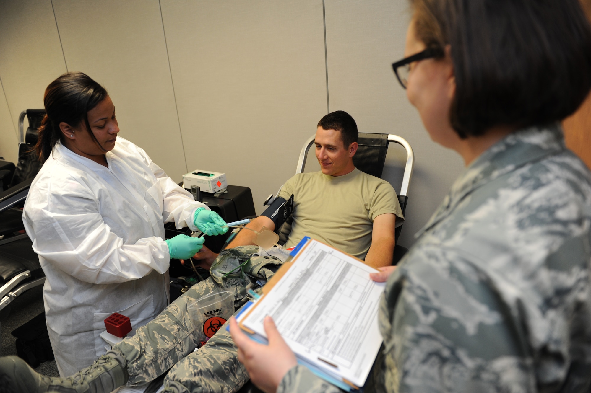 Amber Horne, 81st Diagnostic and Therapeutics Squadron medical lab technician, and 1st Lt. Melissa Miller, 81st MDTS blood donor center officer in charge, draw blood from Airman Basic Taylor Gull, 336th Training Squadron, during a blood drive at the Sablich Center June 21, 2016, Keesler Air Force Base, Miss. To donate you must be at least 18 years old, have been feeling well for at least three days, be well hydrated and have eaten prior to donating. Tattoos, acupuncture, foreign travel and some immunizations can defer volunteers from donating for up to 12 months. The Keesler Blood Donor Center is located in the 81st Medical Group's Arnold Medical Annex. (U.S. Air Force photo by Kemberly Groue)