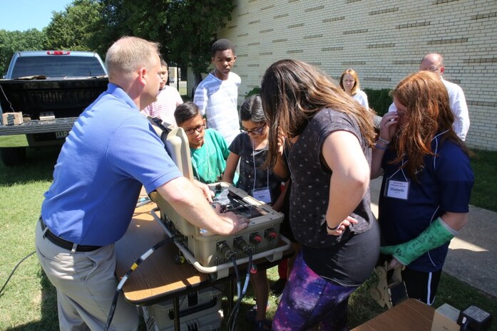 John Peters, a product manager at Marine Corps Systems Command, talks to students about a portable solar panel system used by Marines during the Quantico Middle/High School’s Science, Technology, Engineering and Math Summer Academy June 13-17 aboard Marine Corps Base Quantico, Virginia. The STEM Education Alliance—a partnership between the Department of Defense and the College of William and Mary—hosts the camp annually for the QMHS students. (U.S. Marine Corps photo by Mathuel Browne) 