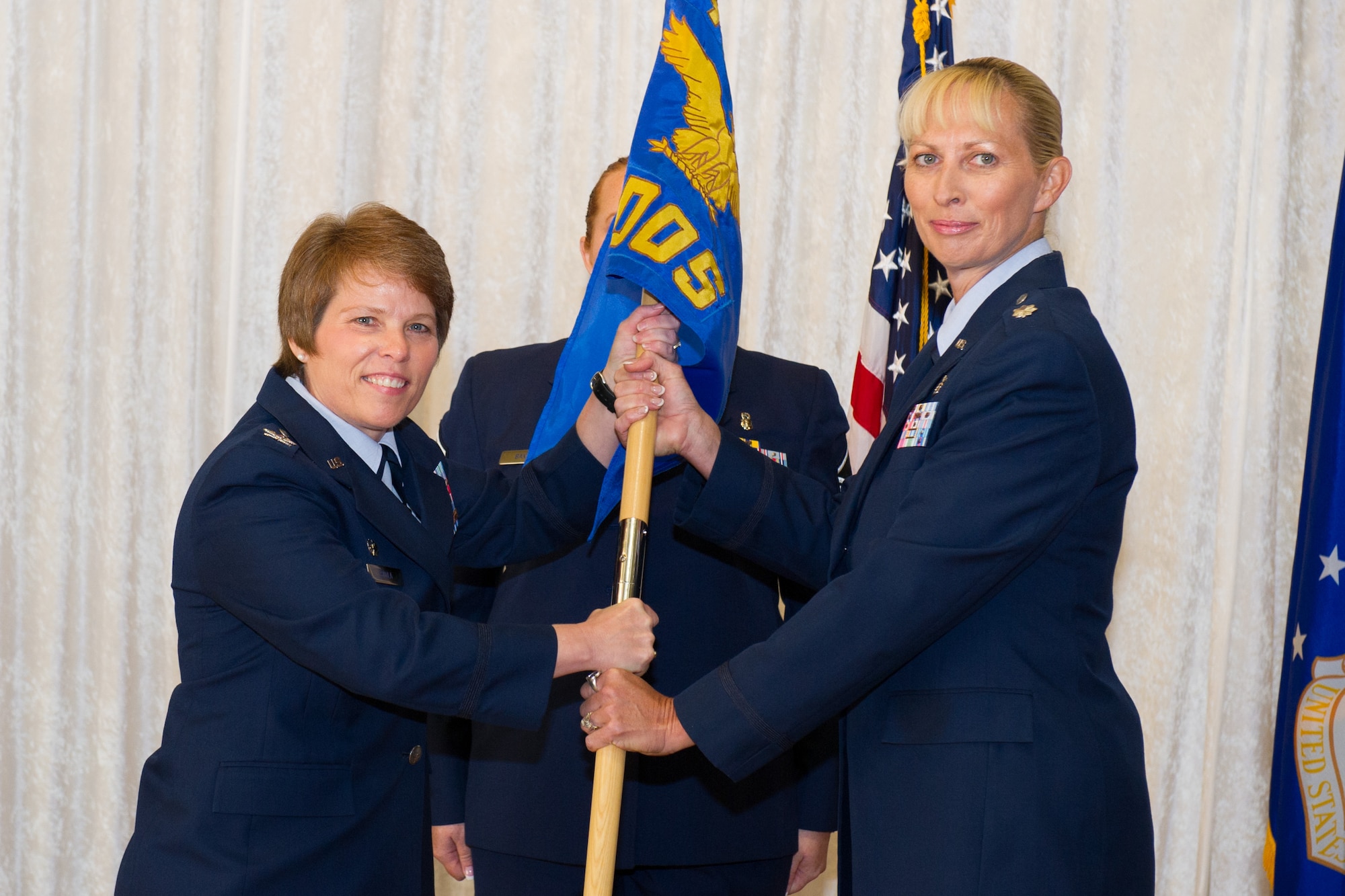 Col. Julie Stola, 45th Medical Group commander, presents Lt. Col. Donna Fox, 45th Medical Operations Squadron commander, with the guidon during a change of command ceremony June 24, 2016, at Patrick Air Force Base, Fla. Changes of command are a military tradition representing the transfer of responsibilities from the presiding official to the upcoming official. (U.S. Air Force photo/Matthew S. Jurgens/Released)