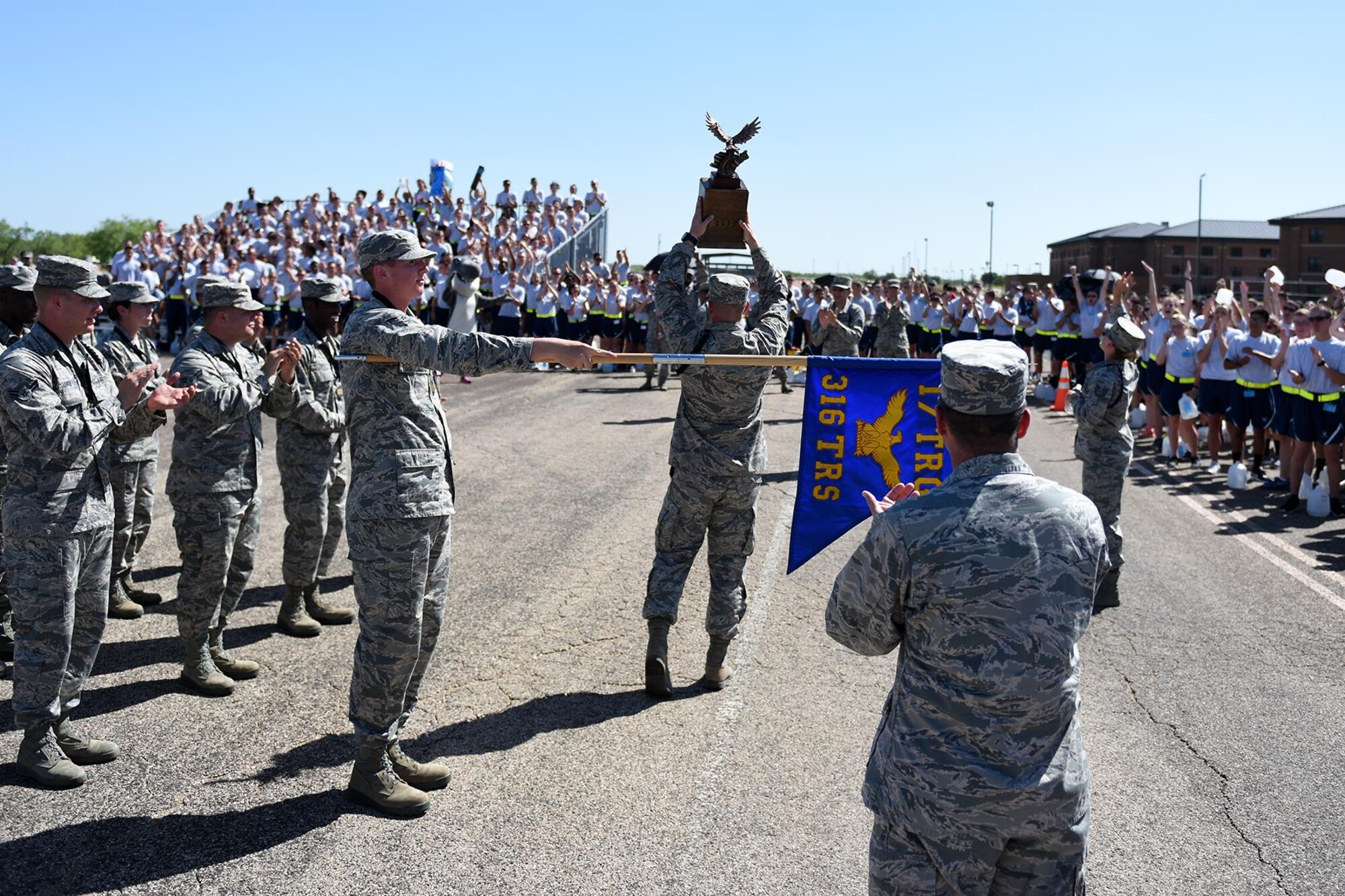 The 316th Training Squadron celebrates their victory after winning the overall award for the drill competition on the flight line at Goodfellow Air Force Base, Texas, June 22, 2016. The squadron also won best regulation drill and exhibition drill performance. (U.S. Air Force photo by Airman 1st Class Caelynn Ferguson/Released)