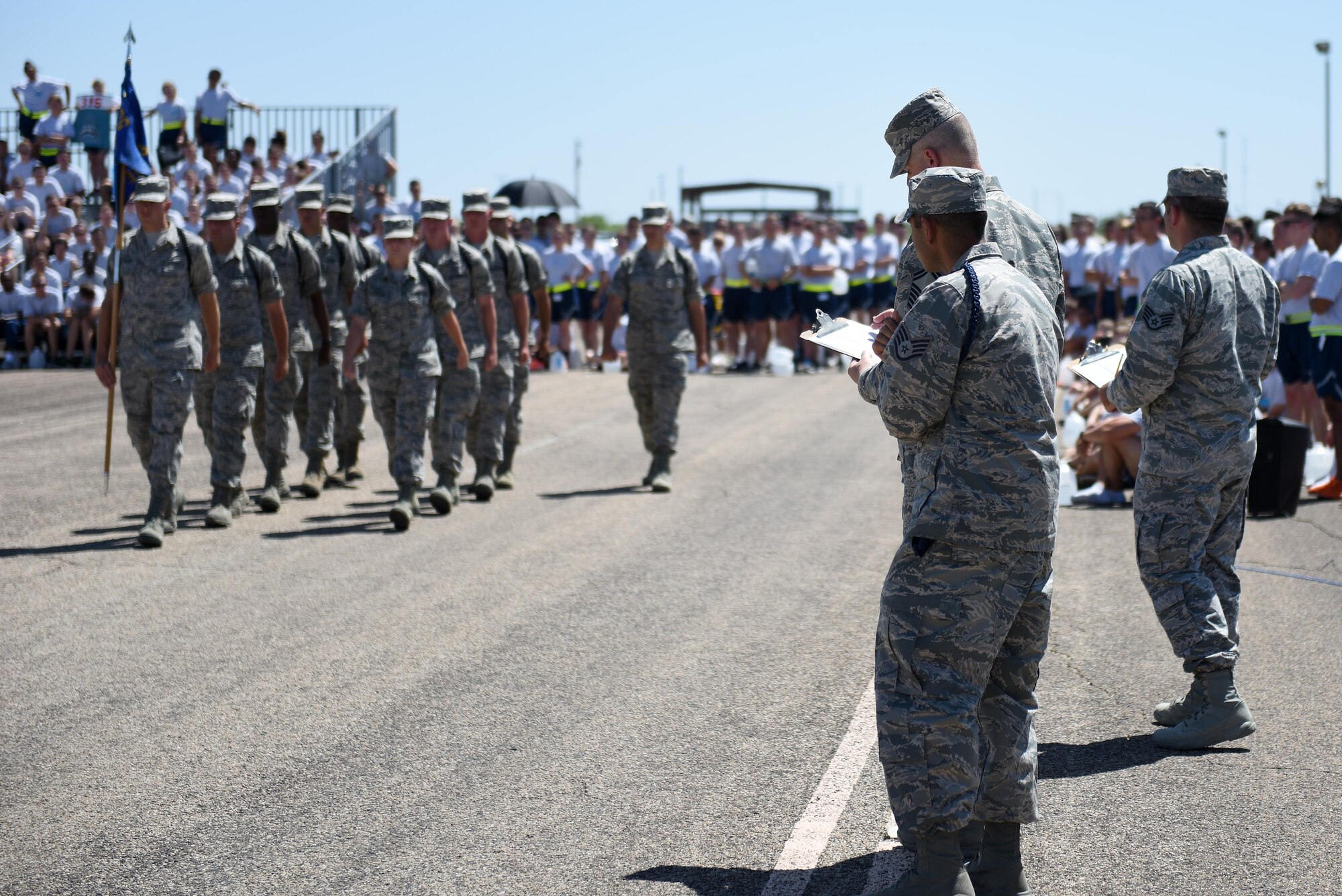 17th Training Group sergeants evaluate students performing regulation drill at the 17th TRG drill competition on the flight line at Goodfellow Air Force Base, Texas, June 22, 2016. Each squadron in the training group competed against each other to win the trophy for individual drill, regulation drill, exhibition drill and spirit of the squadron. (U.S. Air Force photo by Airman 1st Class Caelynn Ferguson/Released)