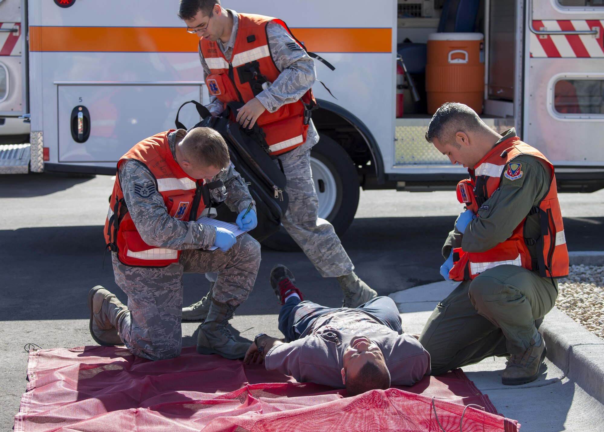 Military members tend to a simulated victim during an active shooter exercise June 23, 2016, in downtown Mountain Home, Idaho. The 366th Medical Group sent first responders to the city center to assist local emergency medical technicians during the active shooter exercise.(U.S. Air Force photo by Senior Airman Jeremy L. Mosier/Released)