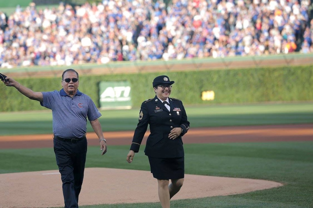 Former U.S. Army Vietnam Veteran, Richard Mejia, left, Purple Heart recipient, raises his veteran's cap to the crowd at Wrigley Field while walking off the mound with his daughter, Army Reserve Sgt. 1st Class Susan Torres, during a Chicago Cubs game military salute, June 19, 2016.
 Torres was in attendance at the Cubs game with her father to throw in a ceremonial first pitch and receive an on-field recognition there.
(Photo by Sgt. 1st Class Anthony L. Taylor)

#MeetYourArmy
#ArmyReserve