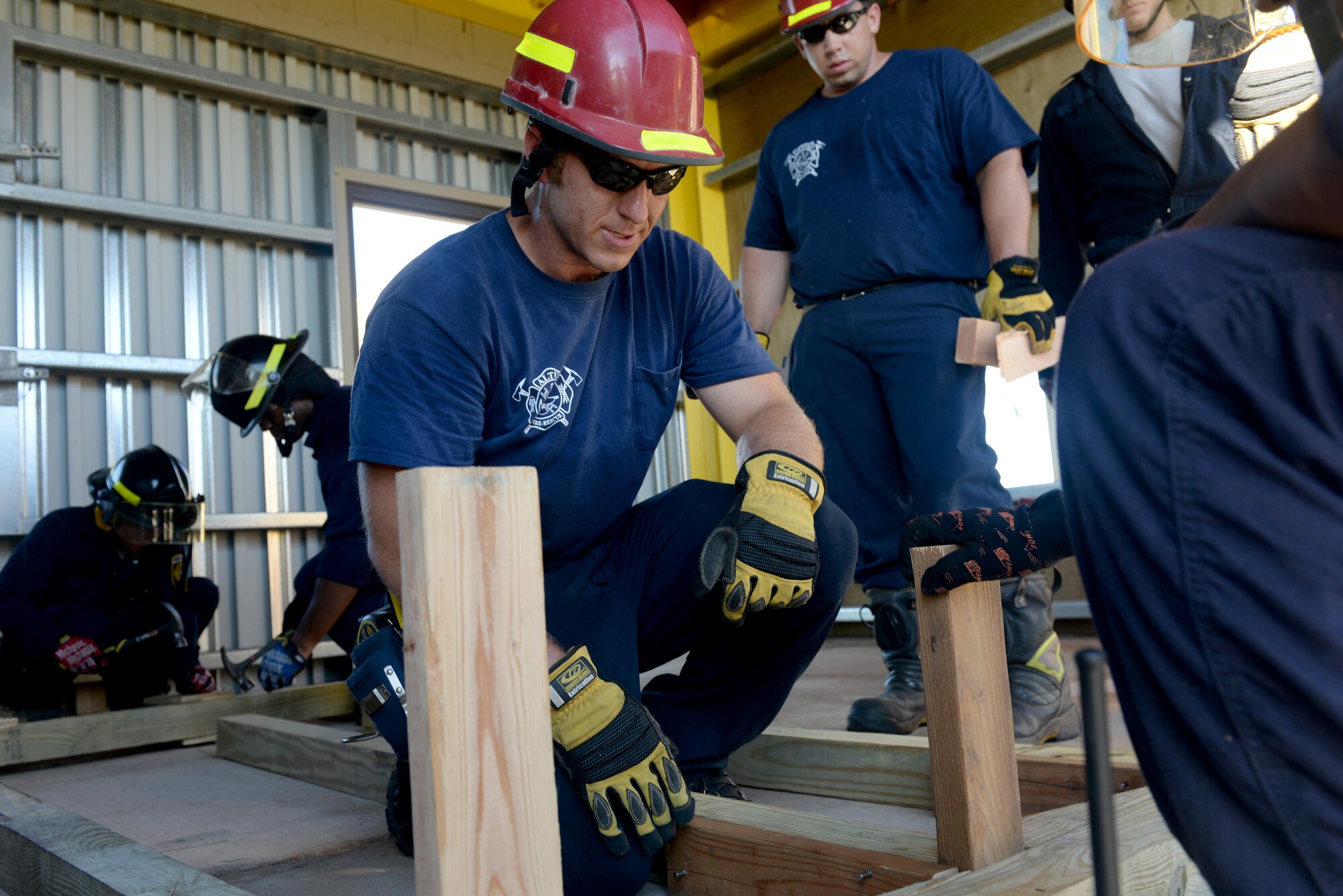 Jake Babcock, City of Altus Fire Department firefighter, directs the placement of a two-by-four during a structural collapse exercise, June 21, 2016, Altus Air Force Base, Okla. The joint training between the Altus Fire Department and Altus Air Force Base Fire Departments was held in an effort to improve the structural collapse rescue techniques and the relationship between the base and City of Altus Fire Departments. (U.S. Air Force Photo by Airman Jackson N. Haddon/Released).