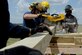 Members from the 97th Civil Engineer Squadron Fire Department and the City of Altus Fire Department saw a board to build a support structure during a structural collapse exercise, June 20, 2016, Altus Air Force Base, Okla. The joint training between the two departments was held in an effort to improve the structural collapse rescue techniques and the relationship between the base and City of Altus Fire Departments. (U.S. Air Force Photo by Airman Jackson N. Haddon/Released).