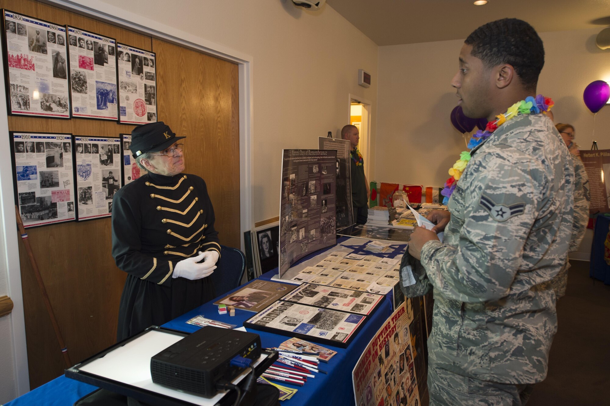 Gayle Baugh, FBI operational support technician, explains the importance of women’s history in the military to Airman 1st Class Travis Hughley, 90th MXS missile space systems maintainer, during the Joint Services Multicultural Event at F.E. Warren Air Force Base, Wyo., June 22, 2016. Informational booths were set up by base organizations such as the chapel, Veterans of Foreign Wars, Asian Pacific heritage, Pride Awareness and Native American heritage groups. (U.S. Air Force photo by Staff Sgt. Christopher Ruano)