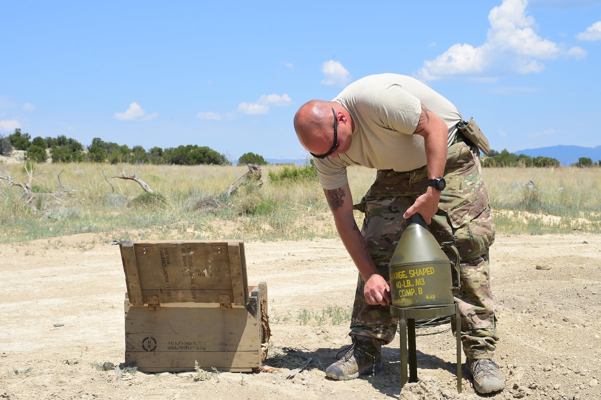 Staff Sgt. Robert Rich, 140th Explosive Ordnance Disposal operator, prepares a 40-pound shape charge to be detonated June 23, 2016, at the Airburst Range on Fort Carson, Colo. Many of the munitions the 140th EOD use are left over from decades of munitions manufacturing. The 40-pound shape charge was manufactured in April of 1953. (U.S. Air Force photo by Airman 1st Class Luke W. Nowakowski/Released)
