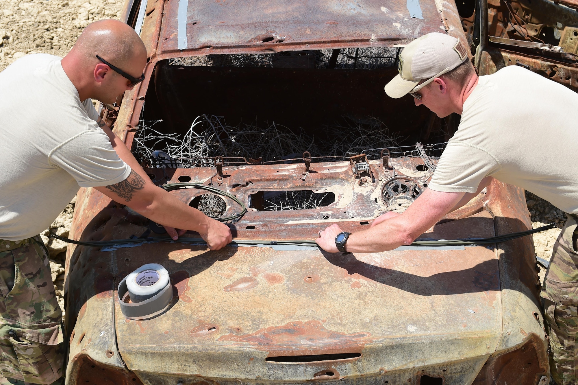 (left) Staff Sgt. Robert Rich, 140th Explosive Ordnance Disposal operator, prepares detonation cord with Airman 1st Class Thomas Benedict, 140th EOD operator, June 23, 2016, at the Airburst Range on Fort Carson, Colo. The two operators worked together to prepare three different explosive charges to see the effects and maintain proficiency. (U.S. Air Force photo by Airman 1st Class Luke W. Nowakowski/Released)