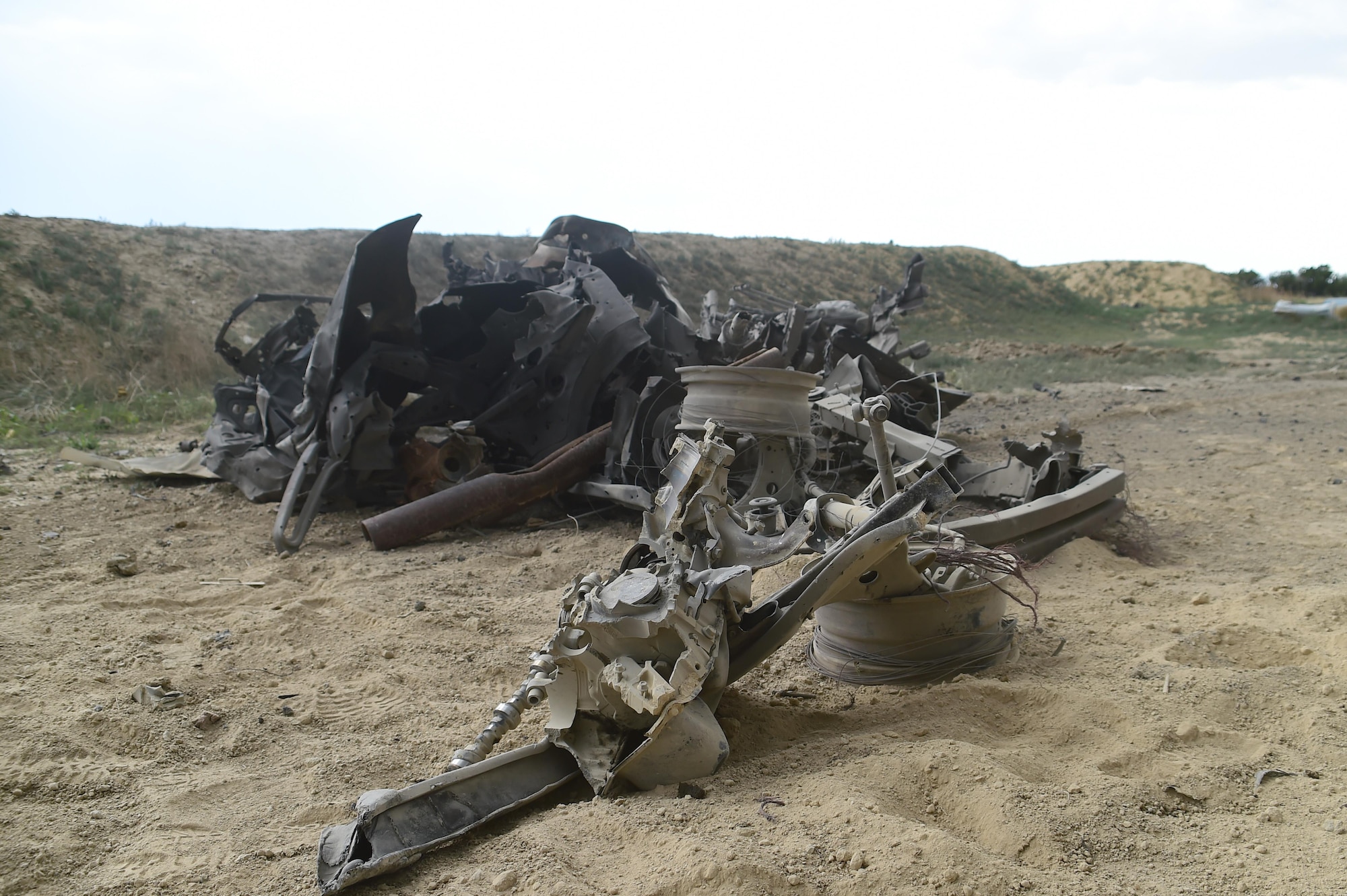 Very little remains of an engine block, which had two C-4 charges stacked on top of it for explosives testing by 140th Explosives Ordnance Disposal June 23, 2016, at the Airburst Range on Fort Carson, Colo. The twisted metal now thrown outside the blast pit shows little resemblance to the car it once was. (U.S. Air Force photo by Airman 1st Class Luke W. Nowakowski/Released) 