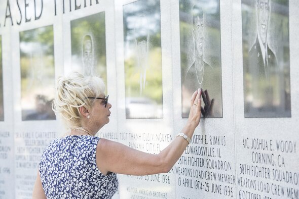 Dari Bradley, aunt of Airman 1st Class Joseph Rimkus, touches a portrait of him on the Khobar Towers Memorial wall June 24, 2016, after the a memorial ceremony at Eglin Air Force Base, Fla. Rimkus was a weapons load crewmember from the 58th Tactical Fighter Squadron who lost his life as a result of the Khobar Towers bombing June 25, 1996. (U.S. Air Force photo by Senior Airman Stormy Archer/Released)