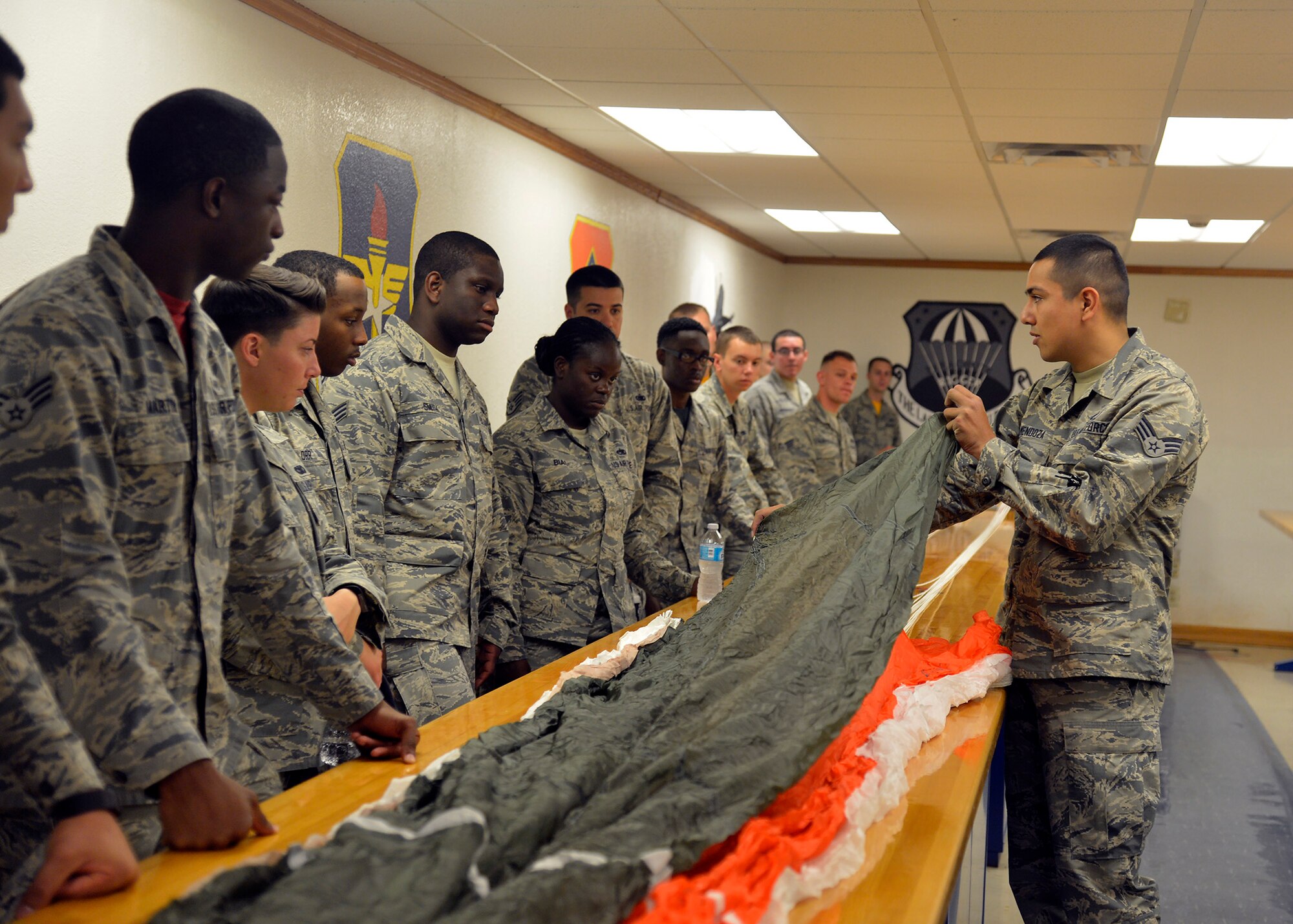 Senior Airman Nathan Mendoza, 56th Operations Support Squadron aircrew flight equipment technician, shows Immersion Program participants the parachute's material June 24, 2016 at Luke Air Force Base, Ariz. The Immersion Program gives Airmen the opportunity to experience the Air Force from a different perspective (U.S. Air Force photo by Senior Airman Devante Williams)