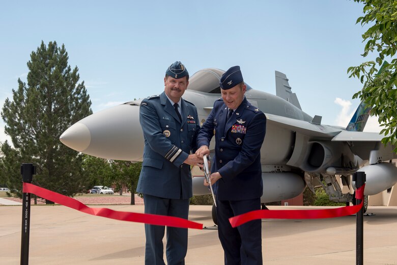 PETERSON AIR FORCE BASE, Colo. – Canadian Lt.-Gen Pierre St-Amand, NORAD deputy commander, and Col. Doug Schiess, 21st Space Wing commander, cut the ribbon during the unveiling of a donated CF-188A Hornet on June 24, 2016 at the Peterson Air Force Base Museum Air Park. The aircraft (tail number 188723) was donated by the Government of Canada to the USAF Heritage Program as a gesture of appreciation for the U.S. and Canada’s longstanding and continued partnership through the North American Aerospace Defense Command. (courtesy photo)