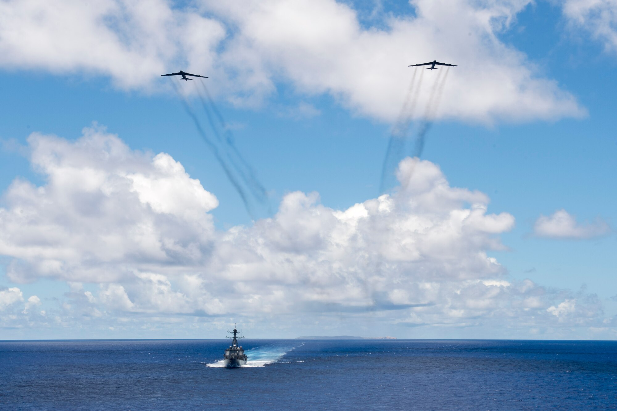 Two U.S. Air Force B-52 Stratofortress bombers assigned to the 69th Expeditionary Bomb Squadron from Andersen Air Force Base, Guam, fly overhead the U.S. Navy USS Spruance (DDG 111) guided missile destroyer following a joint-service bombing exercise in the Pacific Ocean, June 15, 2016. As part of routine continuous bomber presence operations, the bombers’ presence allows U.S. forces to integrate multiple aerial platforms in the Indo-Asia-Pacific region. (U.S. Navy photo by Petty Officer 2nd Class Will Gaskill/Released)