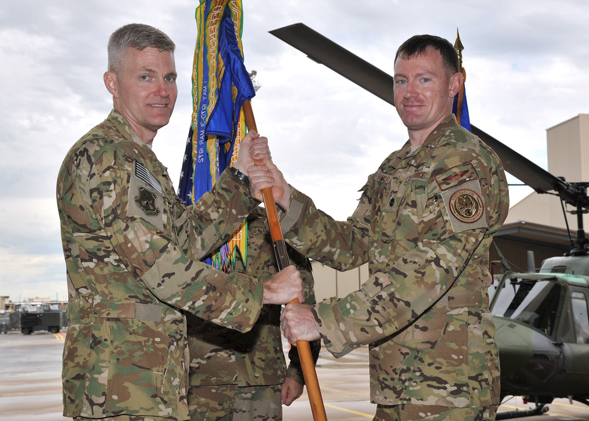 Lt. Col. Joshua Hampton, right, accepts command of the 40th Helicopter Squadron from Col. David Smith, 582nd Helicopter Group commander, June 24 in the squadron’s helicopter hangar at Malmstrom Air Force Base, Mont. The 40th HS provides airborne security for the 341st Missile Wing’s 150 Minuteman III intercontinental ballistic missiles. (U.S. Air Force photo/John Turner)