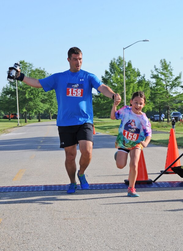 U.S. Air Force Master Sgt. Nathan Ansel, the 509th 
Munitions Squadron NCO in charge of munitions inspections, and his daughter Alexis, cross the finish line after running a 10K during the fifth-annual Striker Life run at Whiteman Air Force Base, Mo., May 21, 2016. Ansel and his daughter finished the 10K with a time of 1:18. The Striker Life event also offered a half marathon and 5K race. (U.S. Air Force photo by Tech. Sgt. Miguel Lara III)
